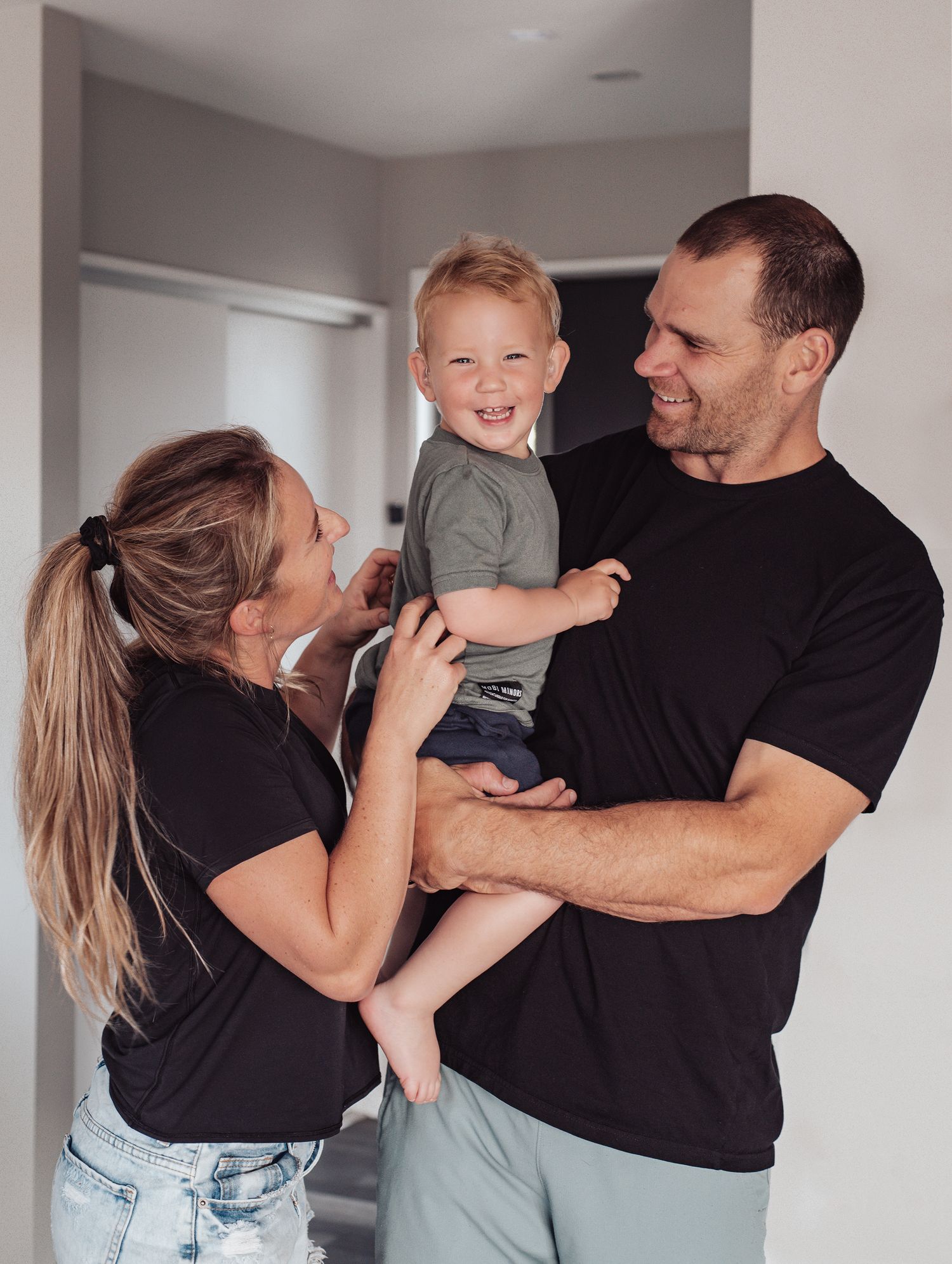 A family shares a joyful moment together in their home hallway.