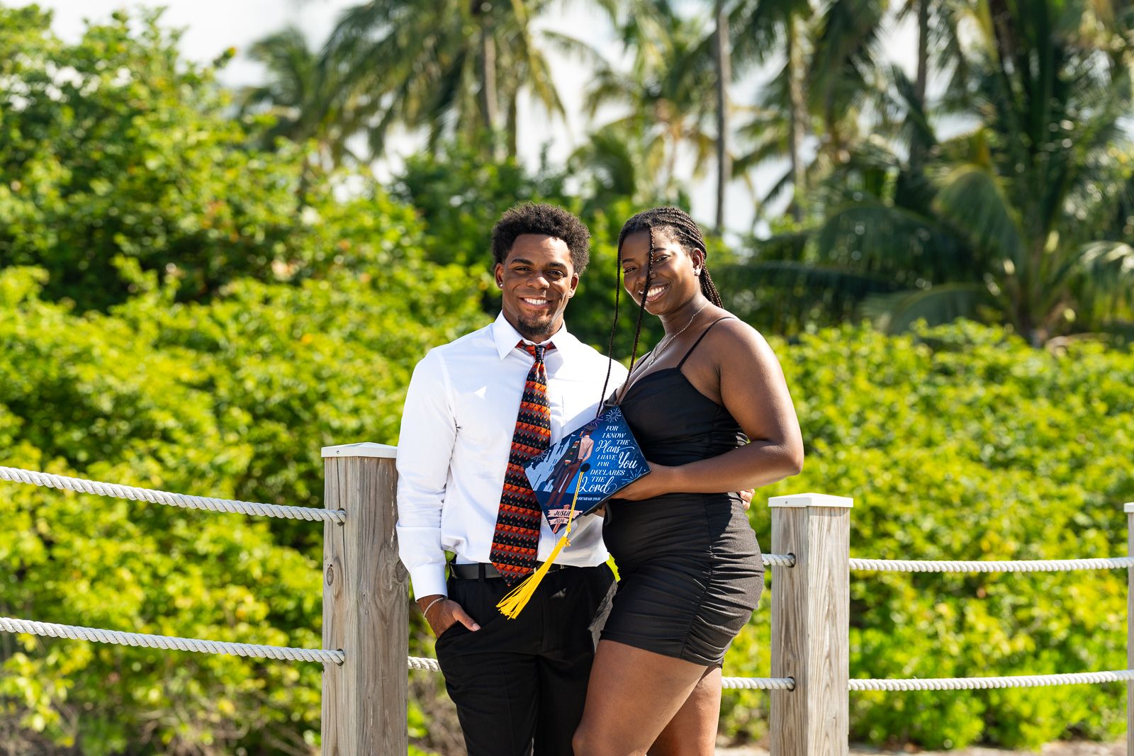 Friends posing together near palm trees on a sunny beach day.