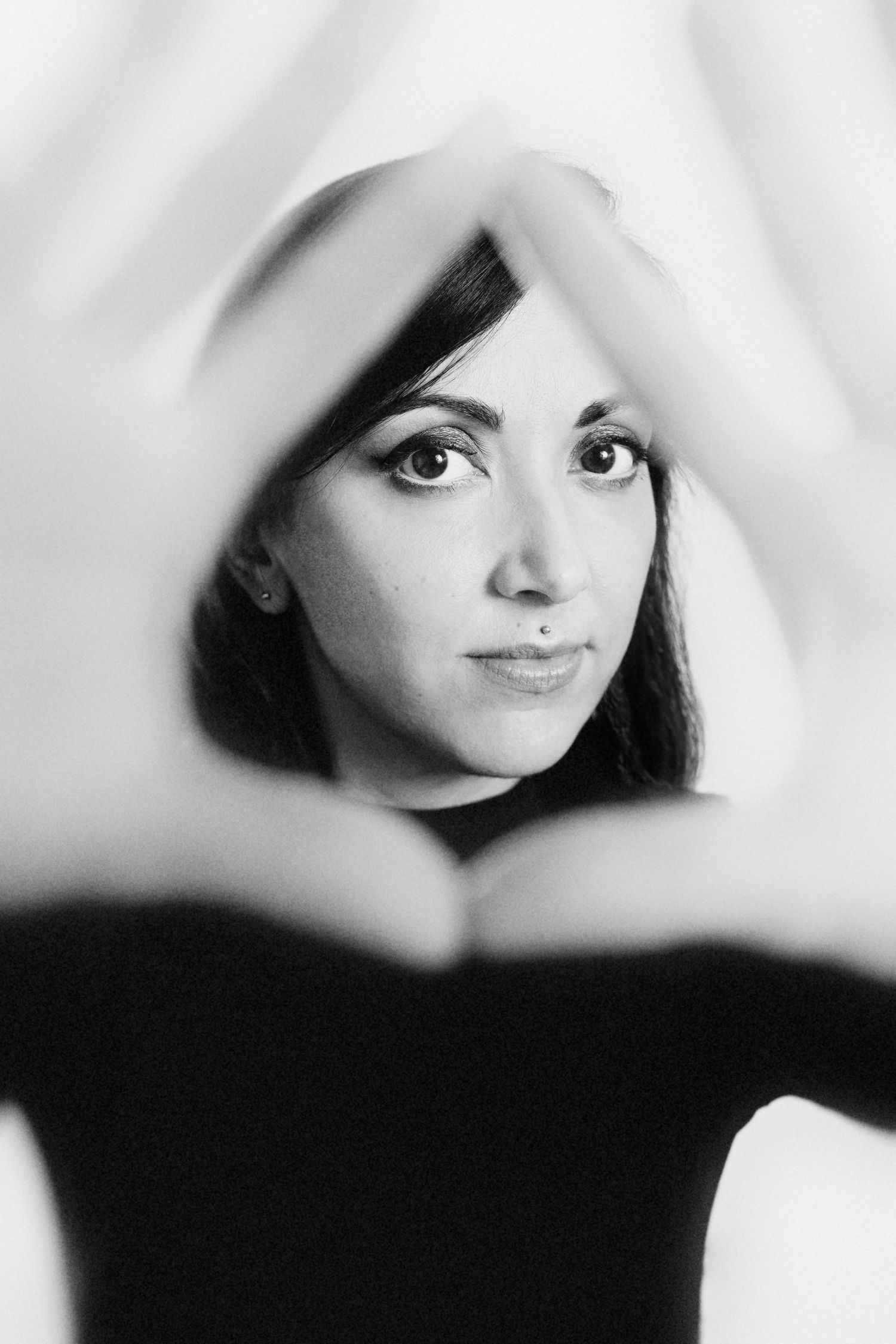 Black and white portrait through fabric creating dreamy, soft-focus effect.