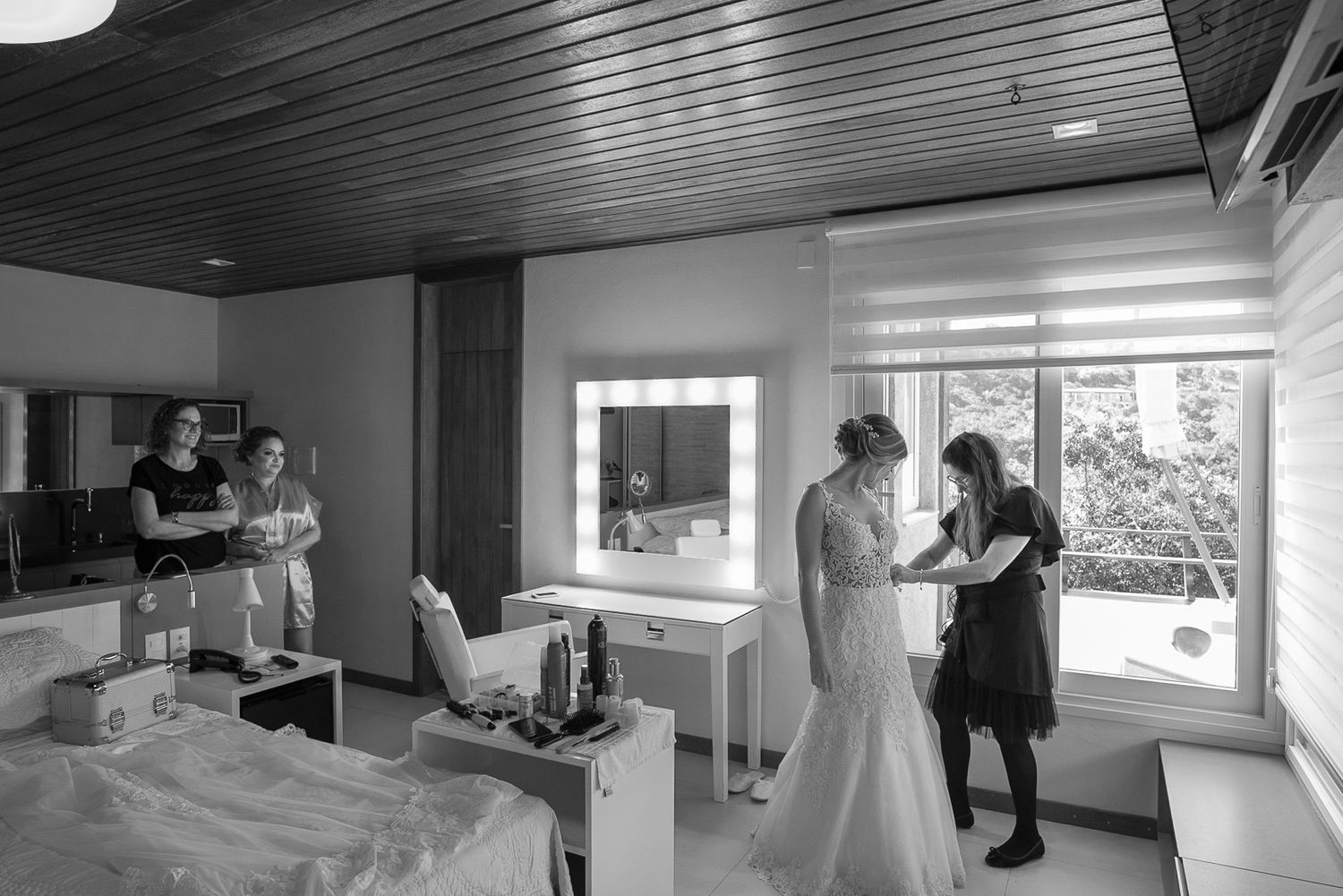 Black and white photo of wedding preparation scene in modern room with natural lighting.