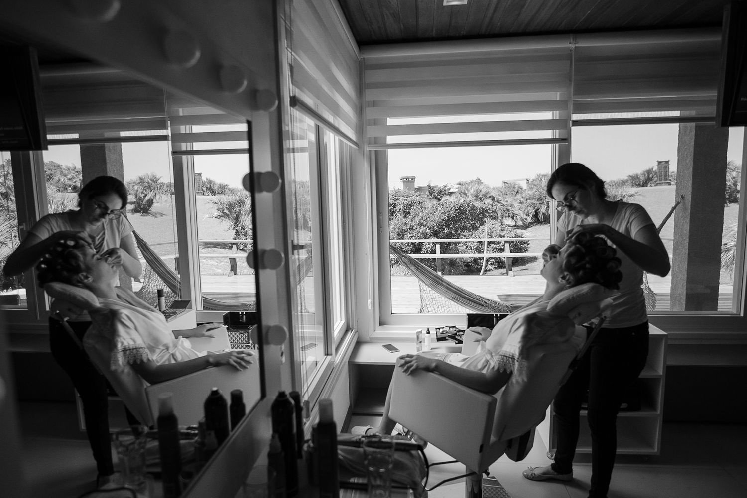 A candid black and white photo capturing preparation moments indoors.