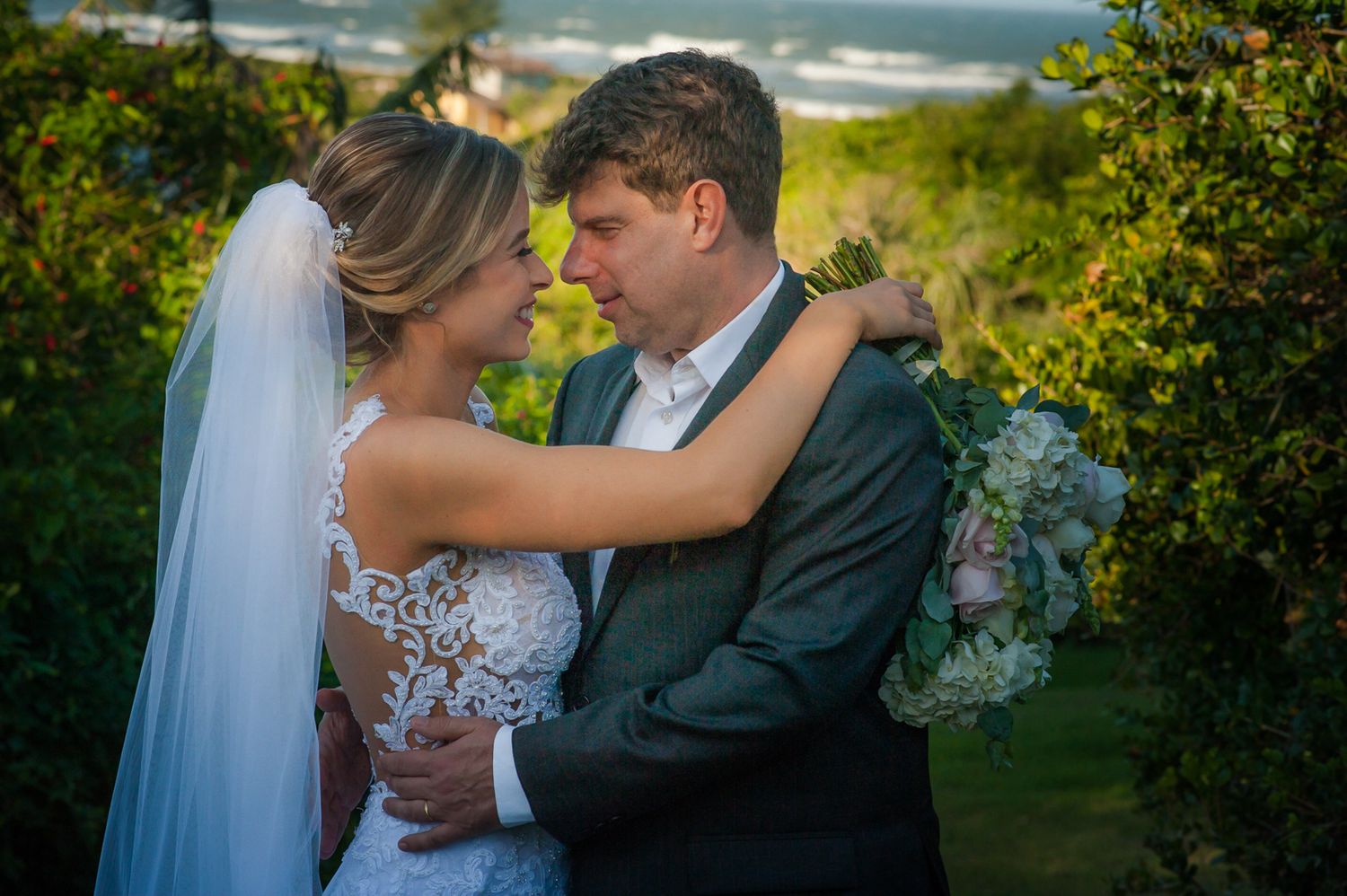 Intimate moment between newlyweds during outdoor wedding photoshoot.