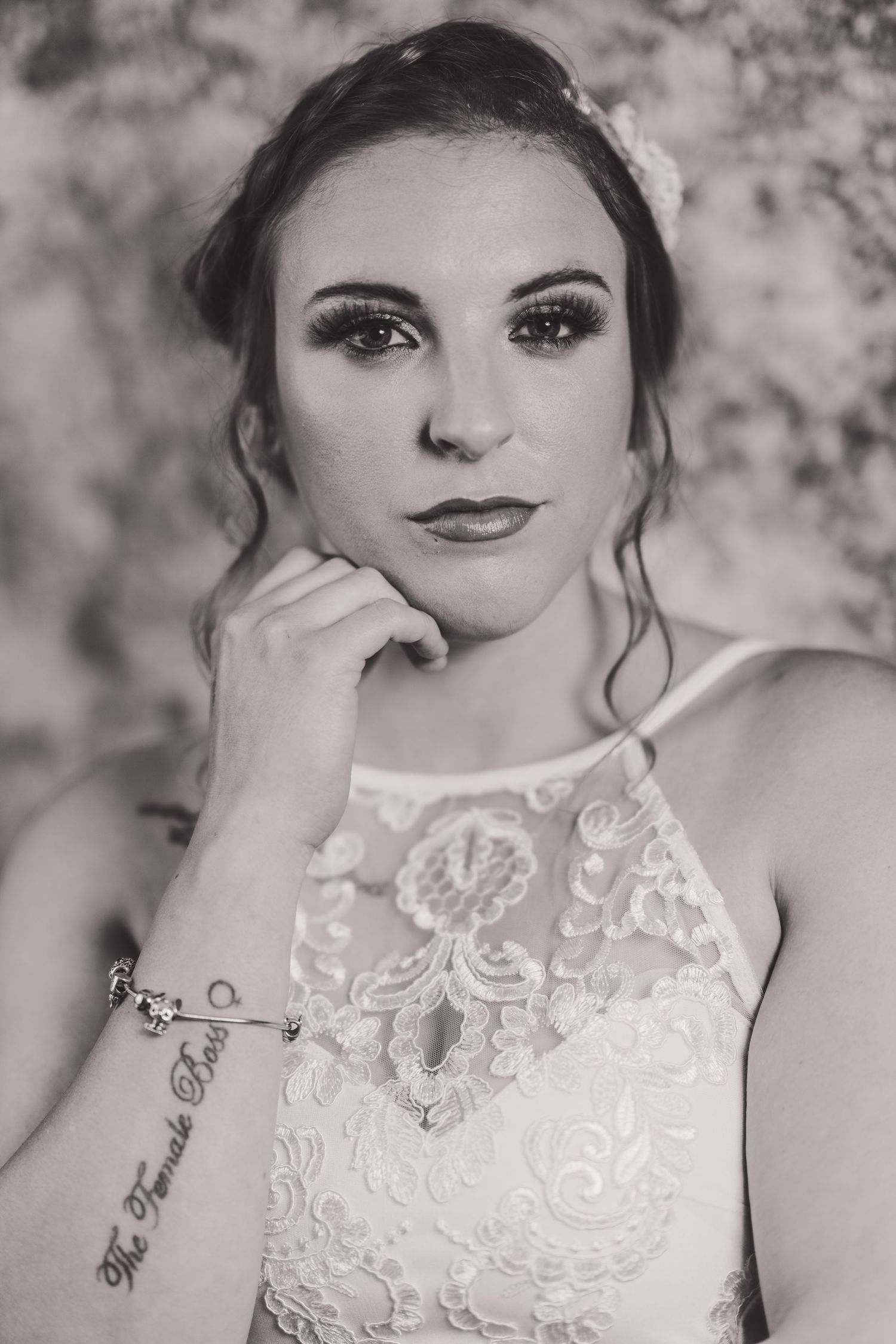 A black and white photo series shows a person wearing an elegant lace dress with delicate embroidered details.