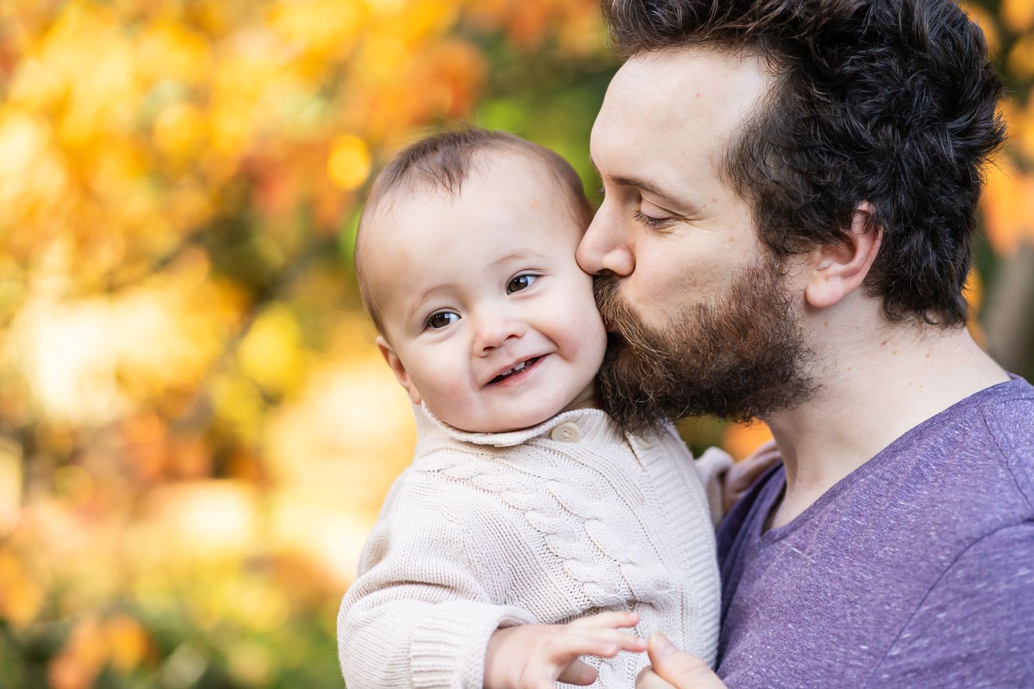 Father kissing his baby son at the Seattle Arboretum.