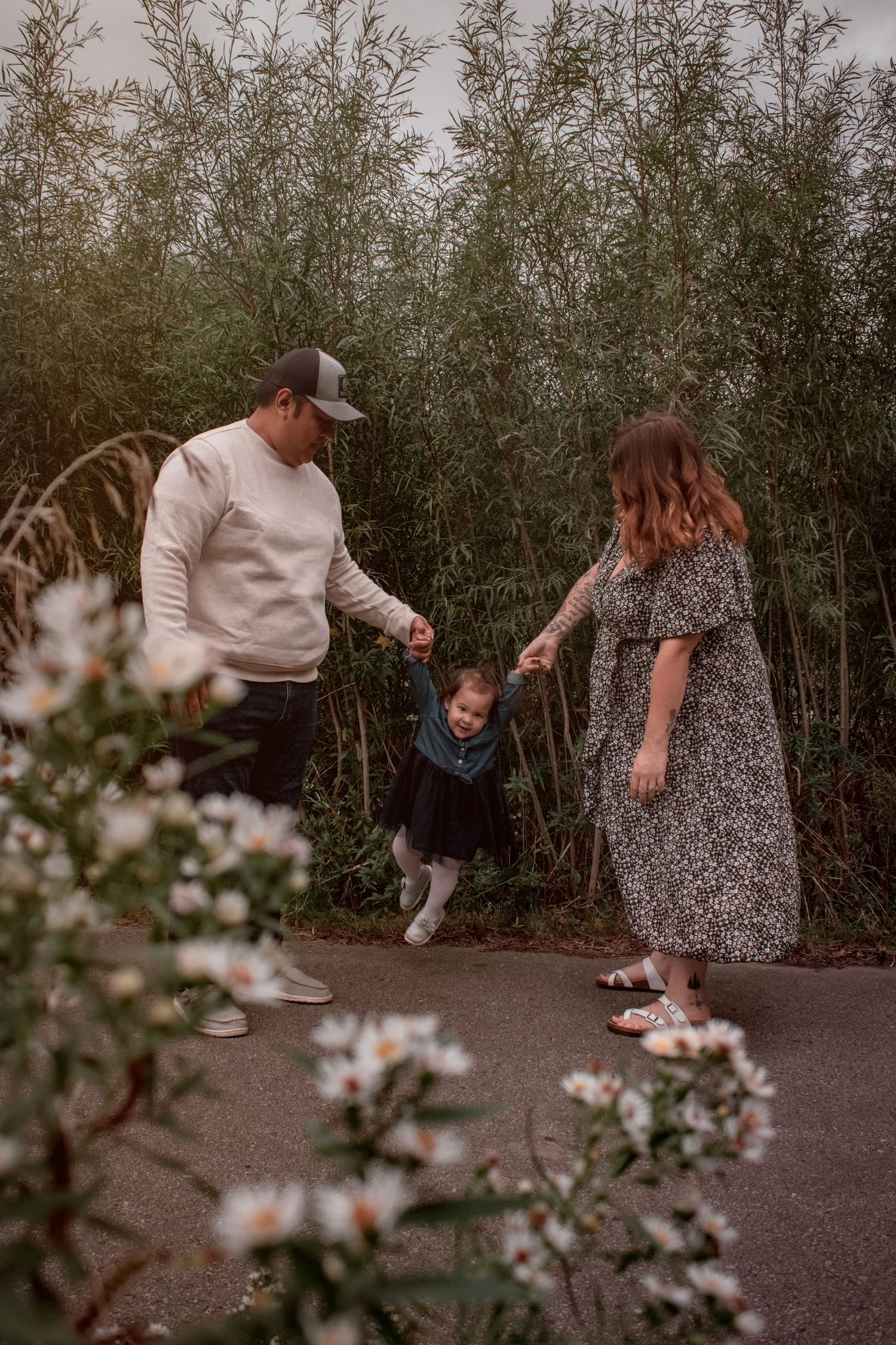 Family walking together through bamboo garden path at dusk.