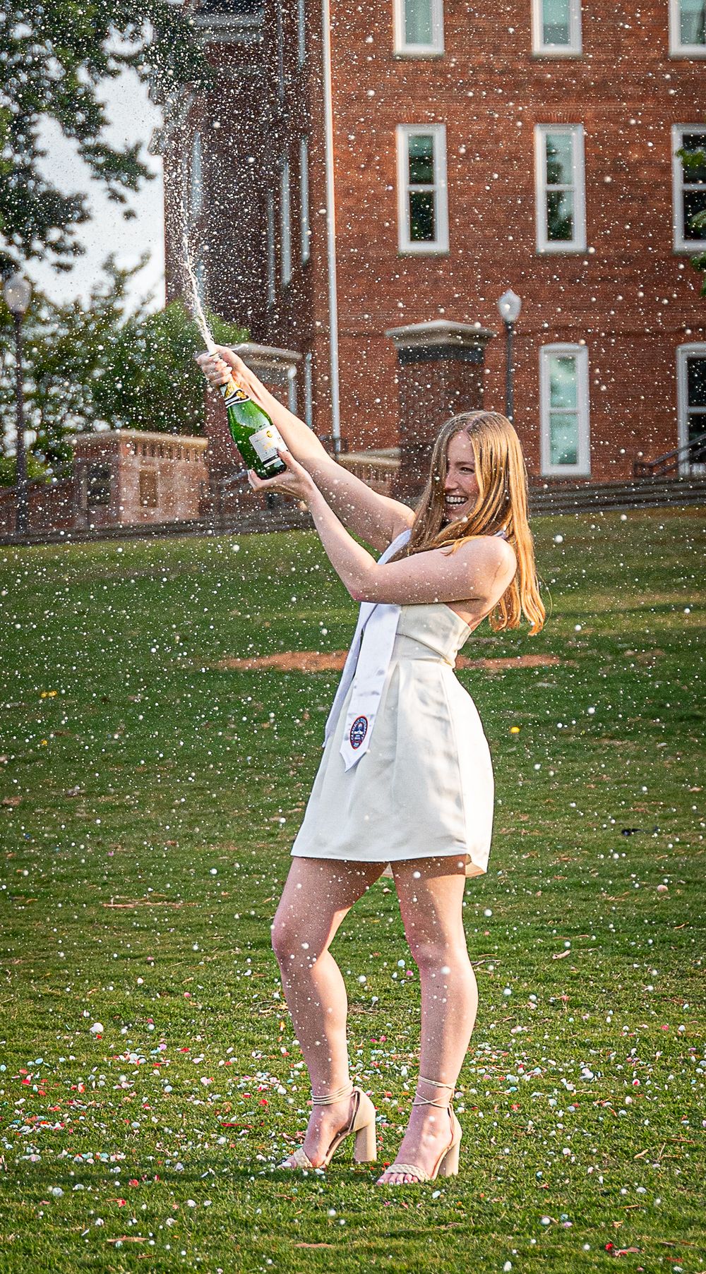 Clemson graduate holding cap at Bowman Field with Tillman Hall in background, Clemson, South Carolina