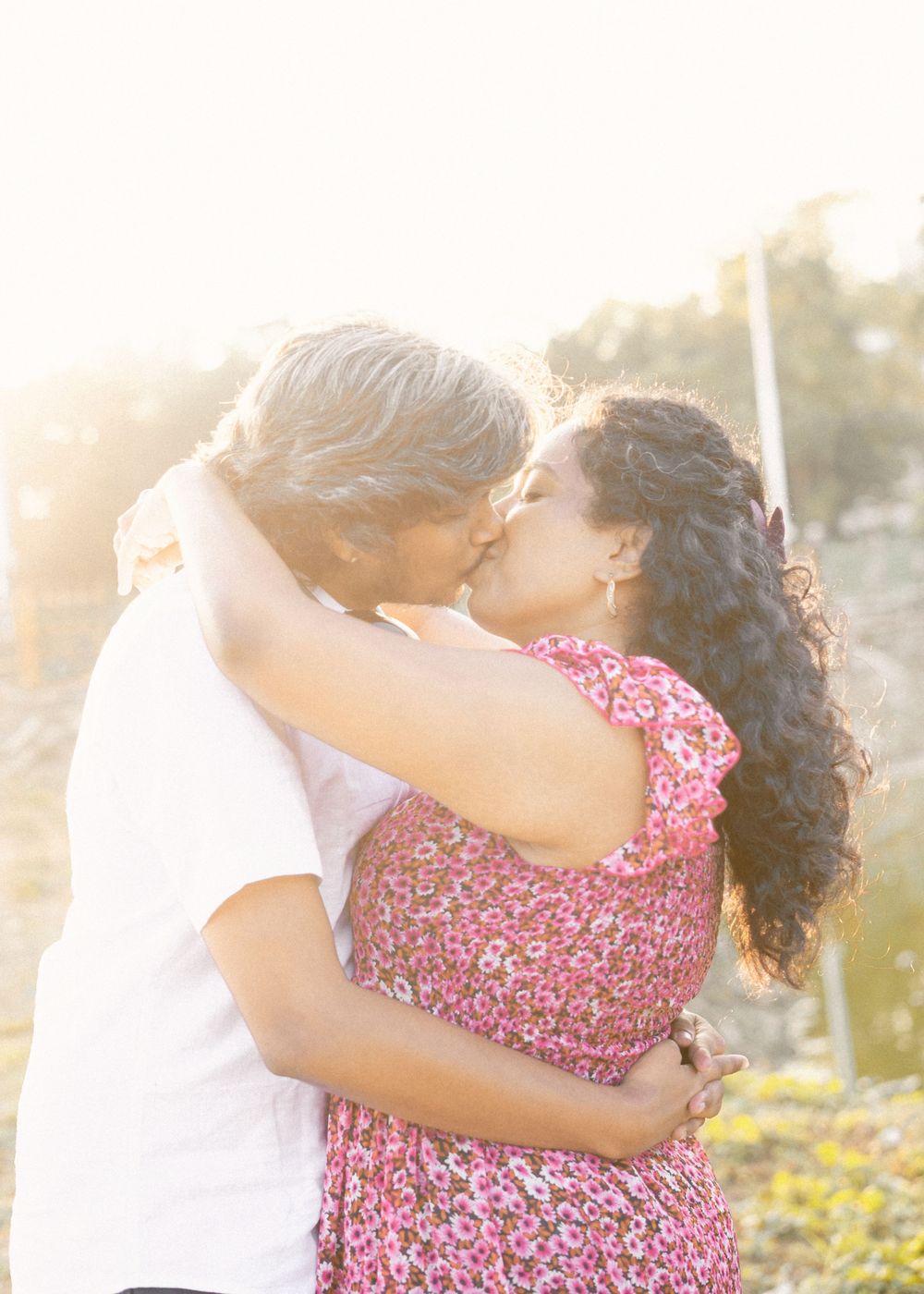 A tender romantic moment captured during sunset with soft golden lighting.