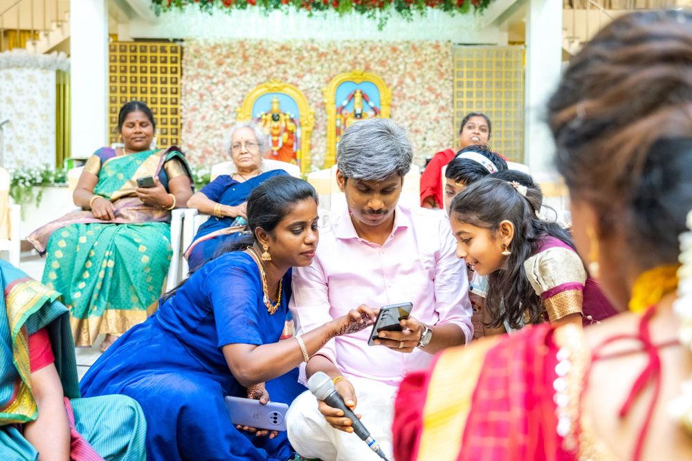 People gathered at a festive event looking at phones and sharing conversations.