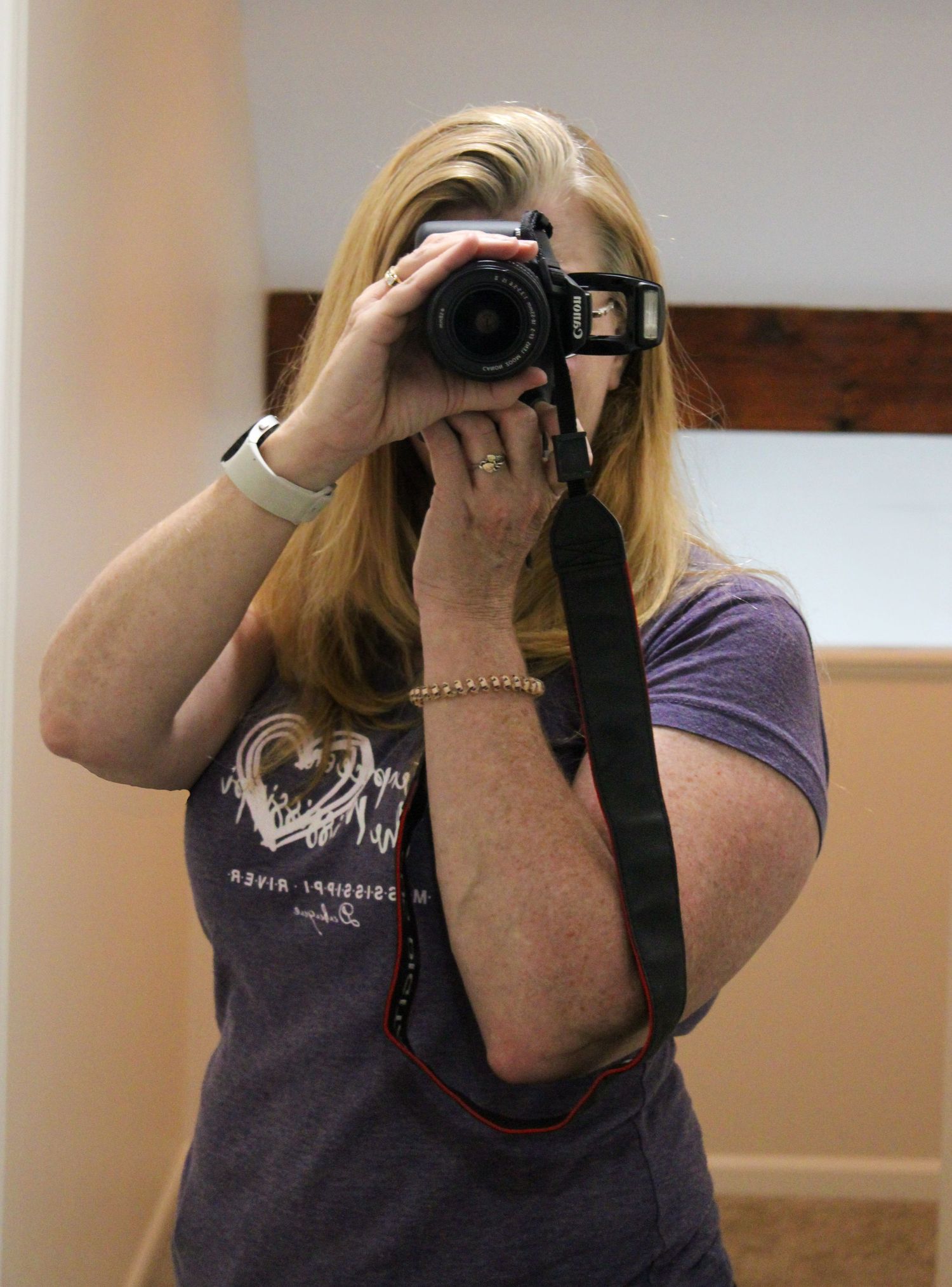 A picture of photographer taking a picture of herself in mirror.