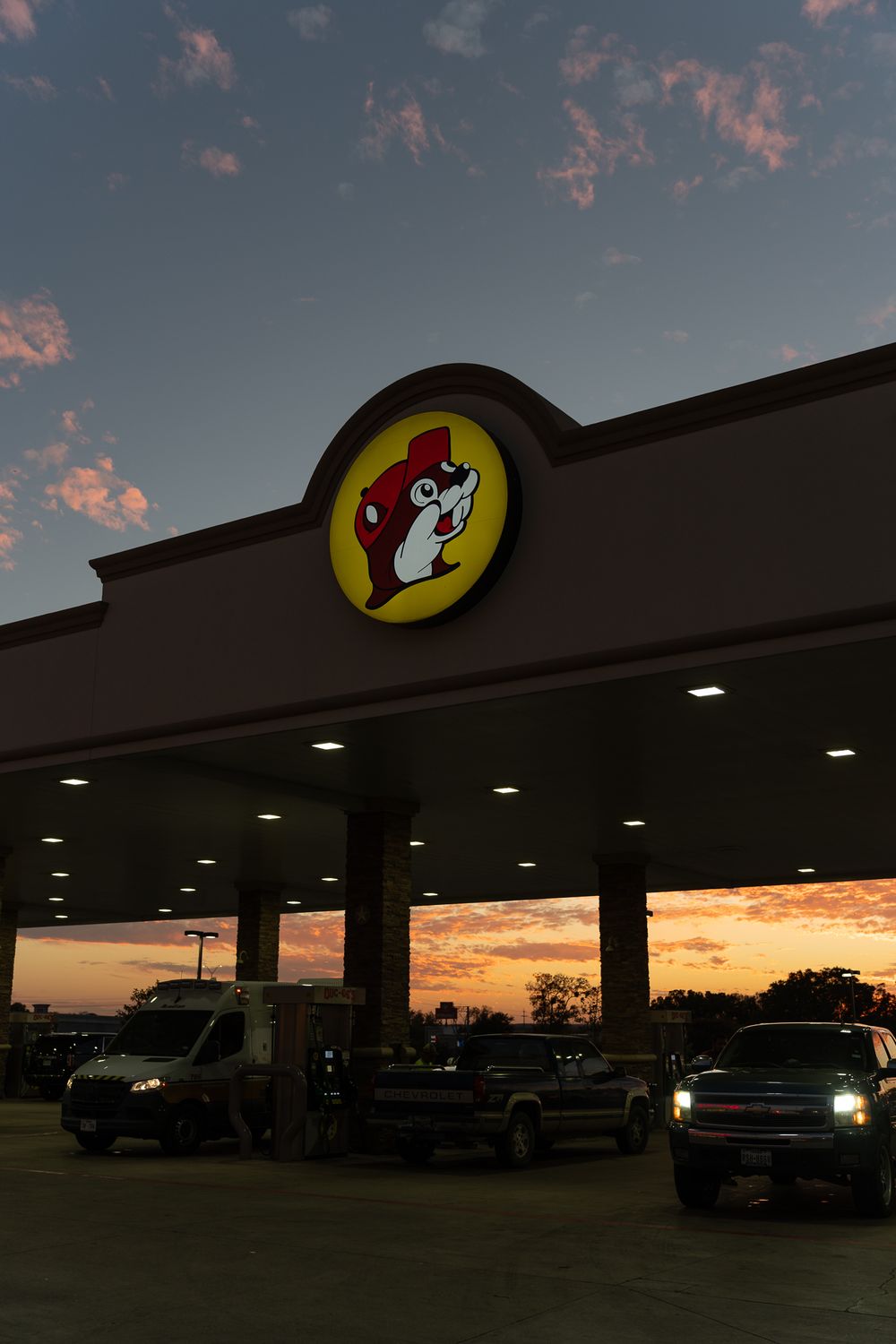 Buc-ee's convenience store sign silhouetted against a dramatic sunset sky.