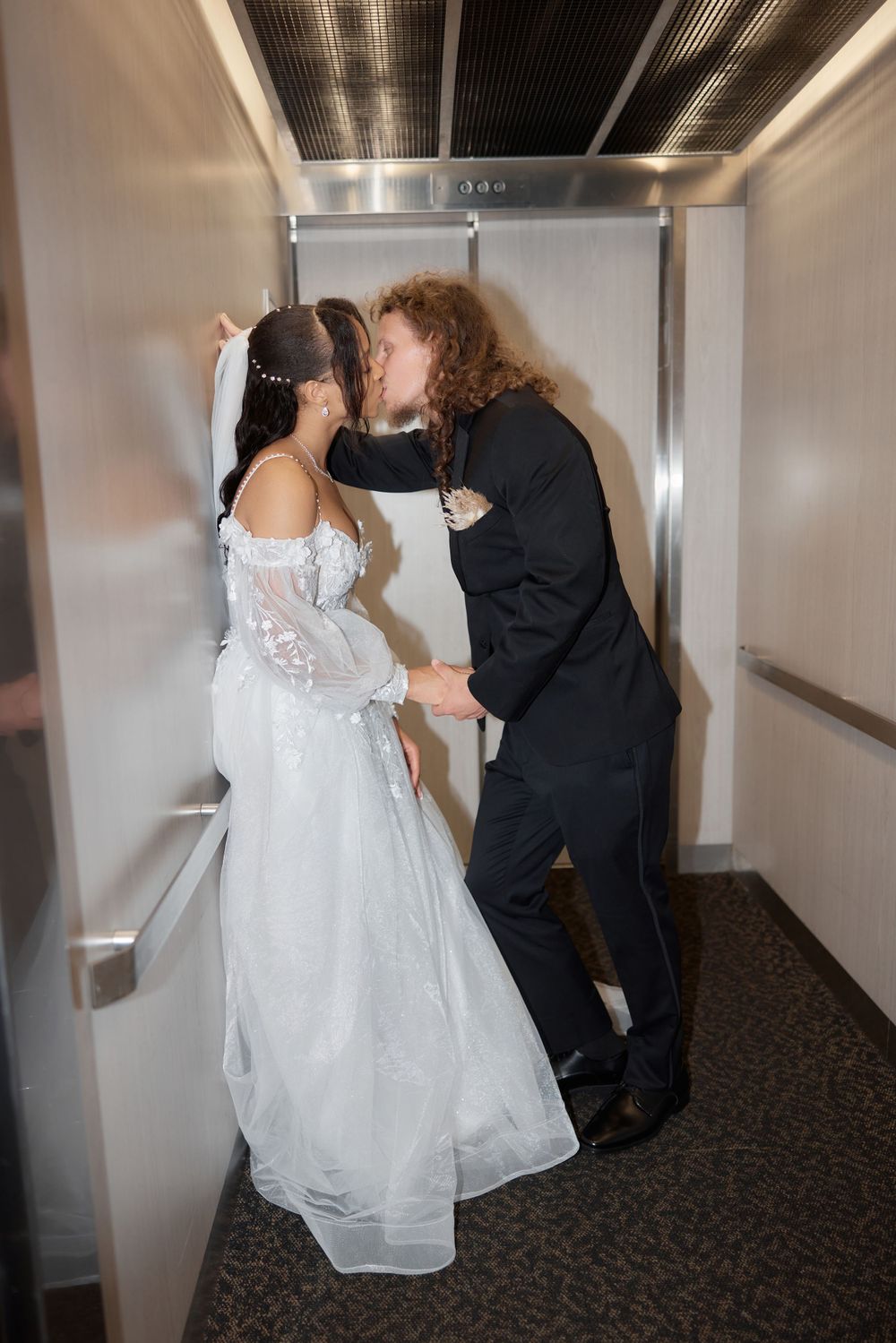 A romantic moment shared in an elevator between newlyweds.