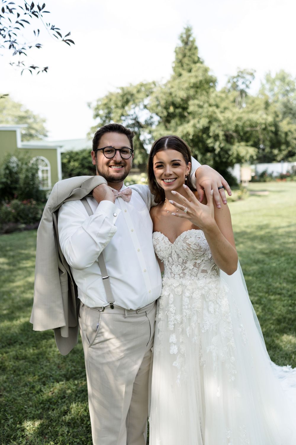 Joyful newlyweds celebrate their wedding day in a sunny garden setting.
