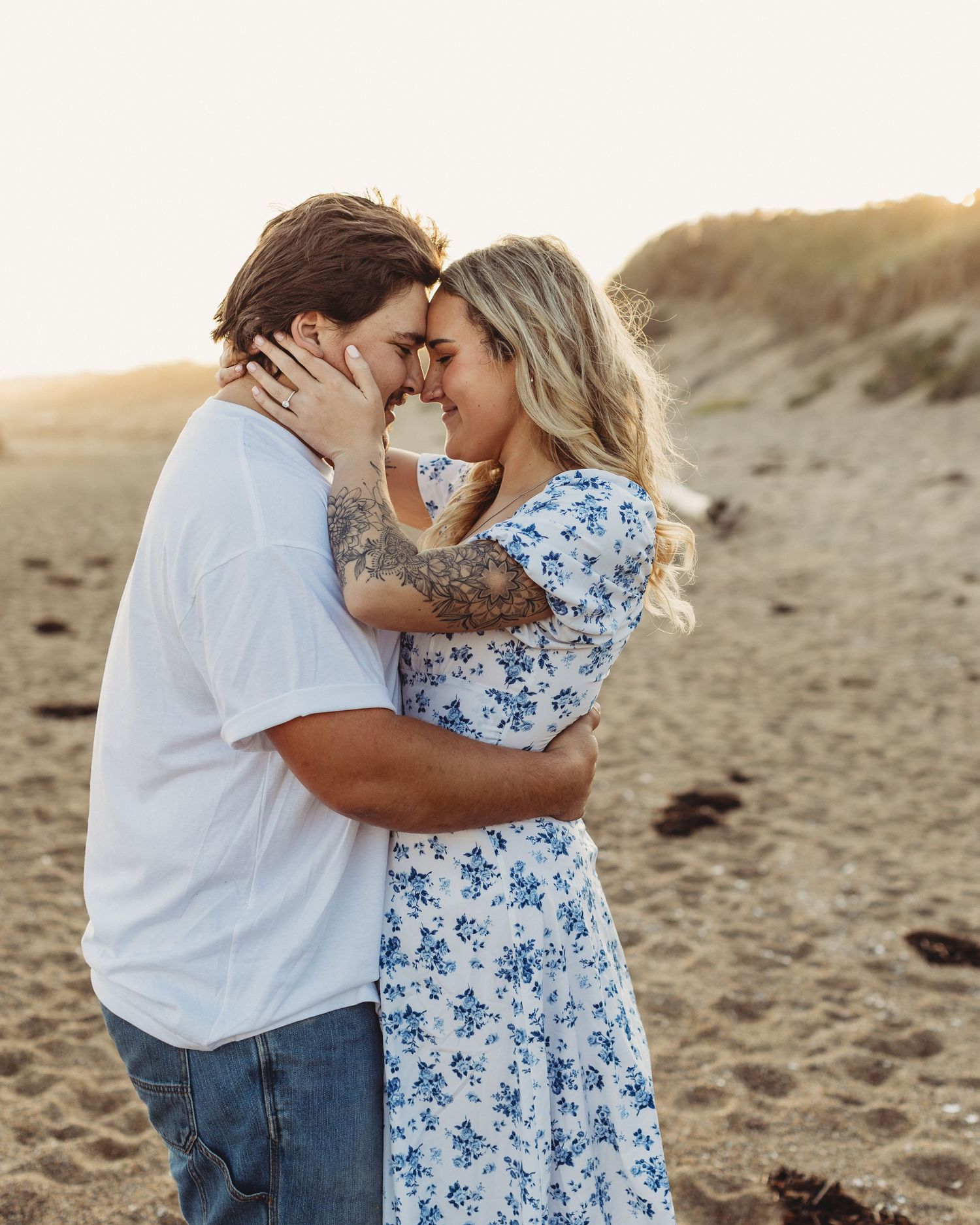 Professional photo of an engaged couple holding each other on the beach
