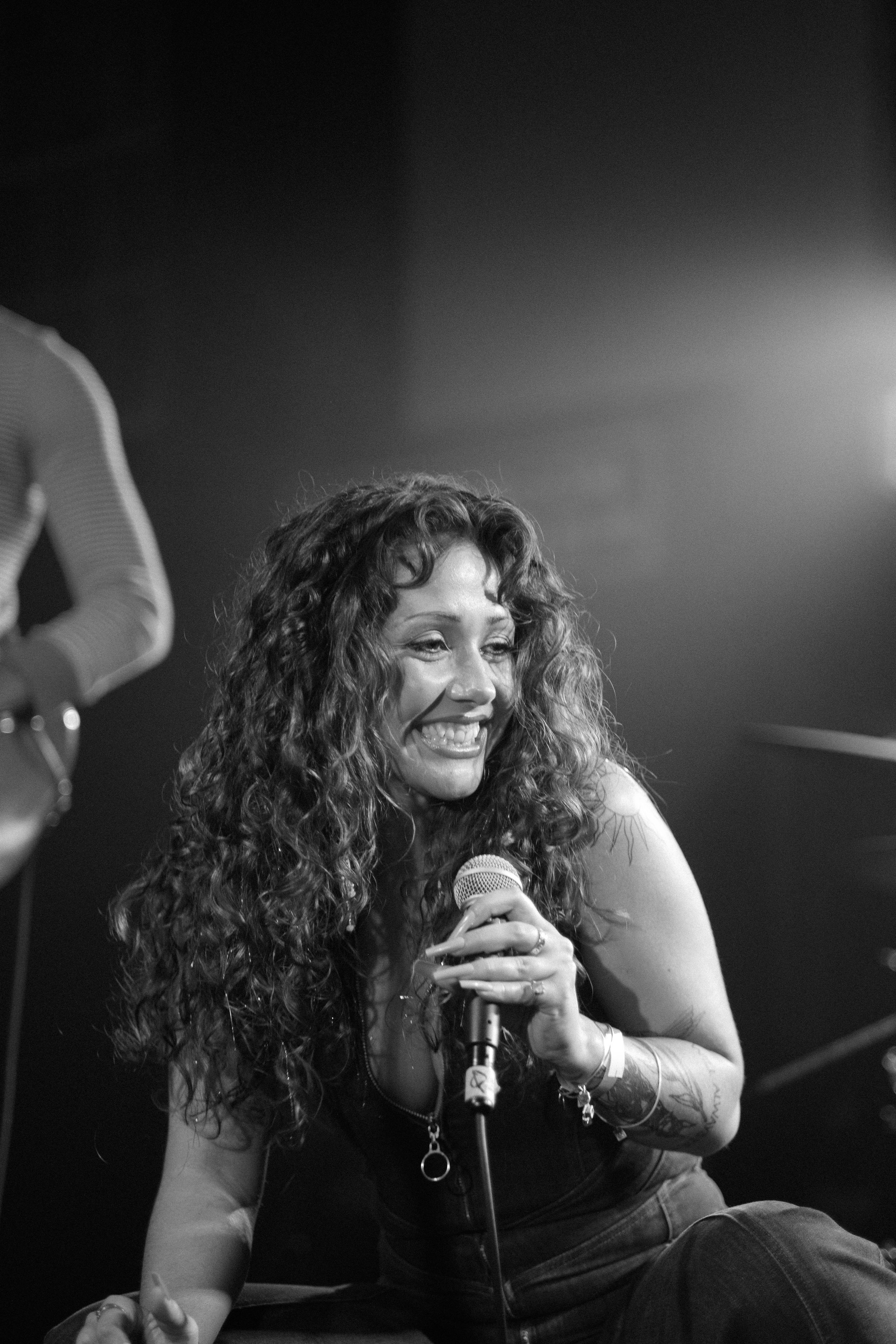A black and white performance photo showing a joyful moment on stage during a concert.