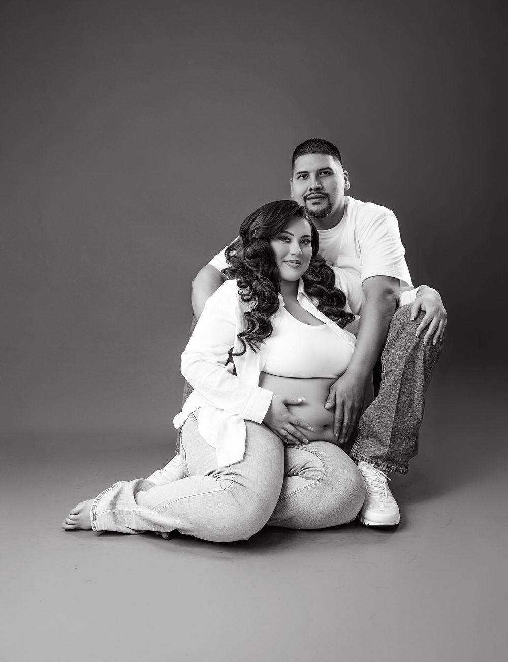 A man and a woman are sitting together in a black and white photograph.