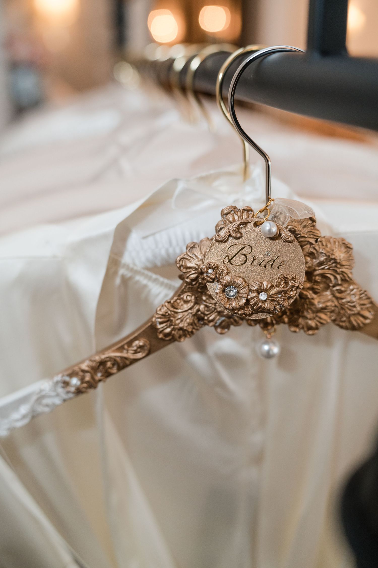 Elegant bridal dress hanger with ornate 'Bride' detail and pearls.