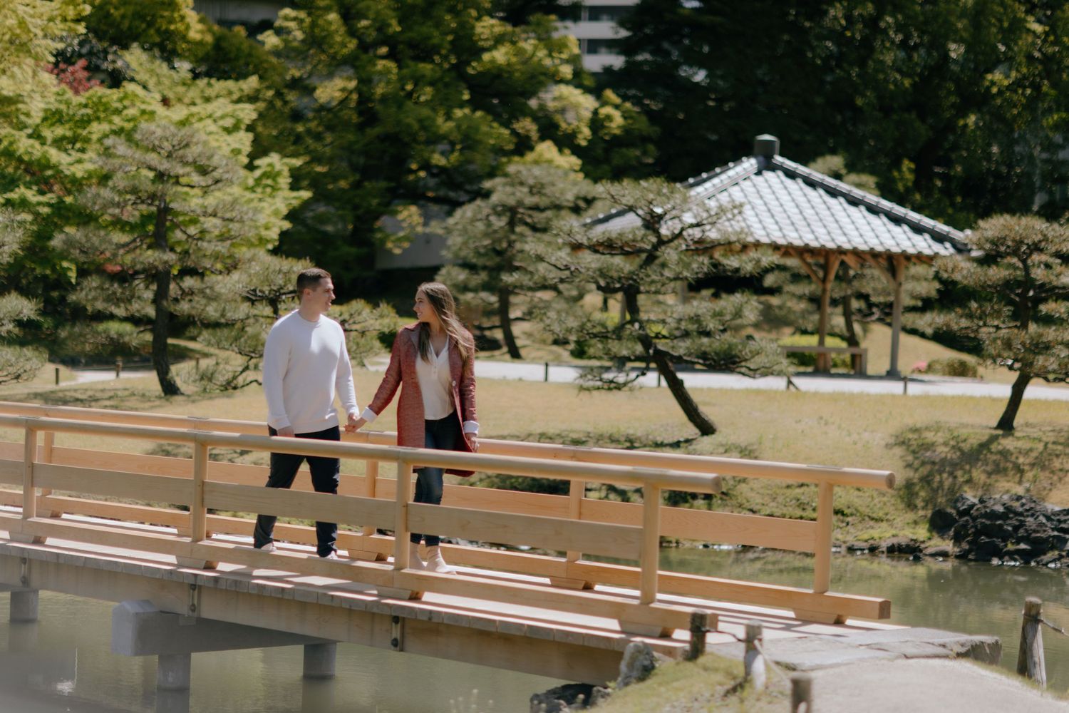 A romantic proposal scene outside a Japanese restaurant with orange lanterns decorating the storefront.