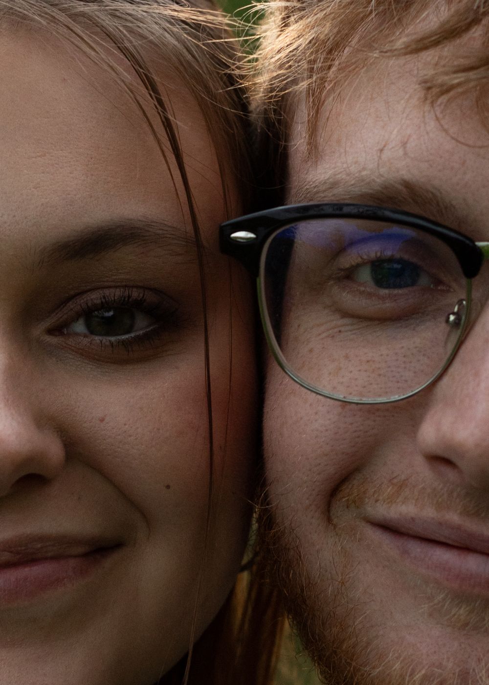 Close-up shot of two people sharing a tender moment outdoors.