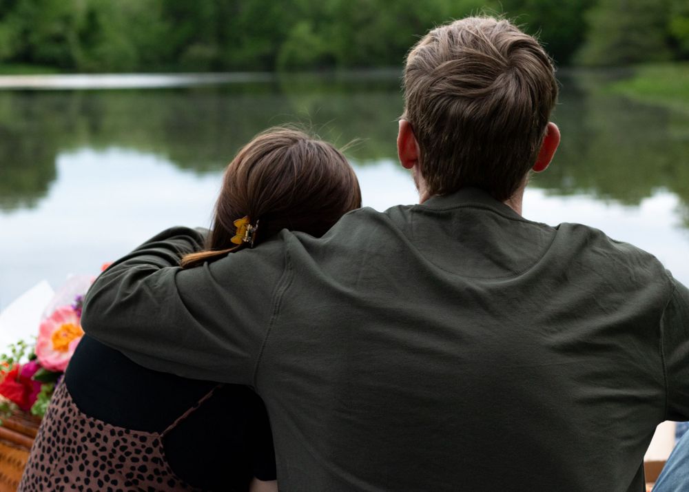 People relaxing by a peaceful lake on a spring afternoon.