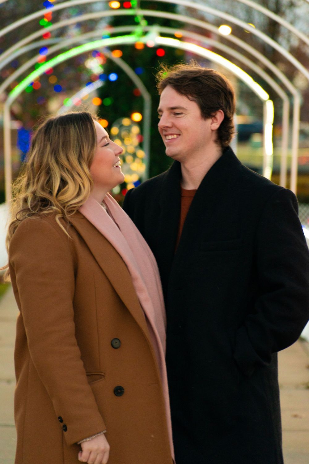 A couple sharing a intimate moment under festive lights during winter.
