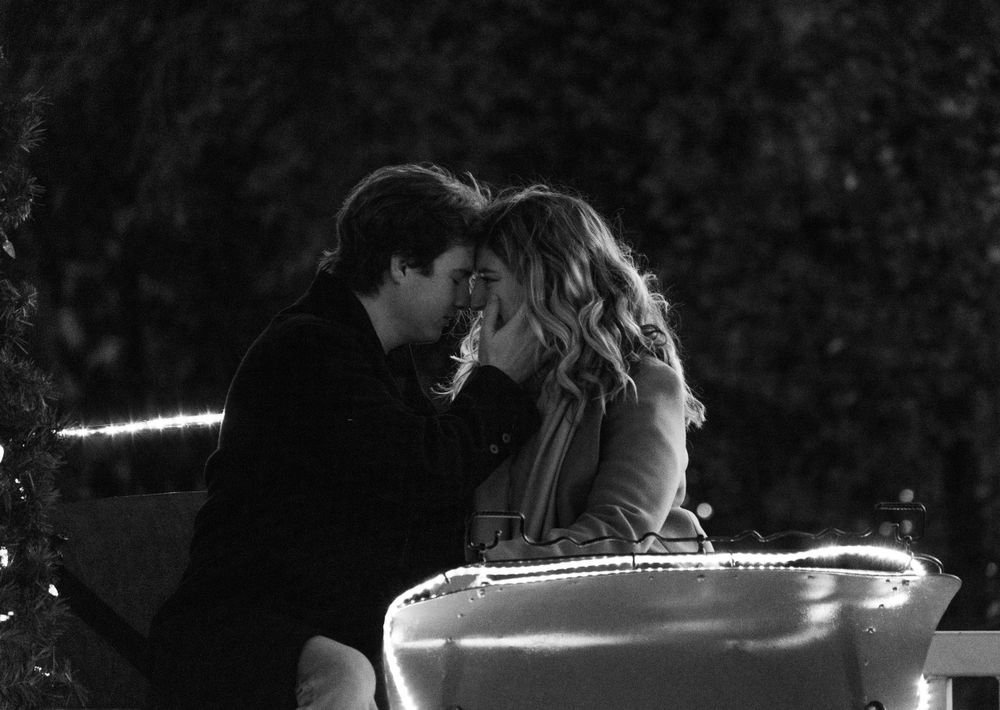 A romantic black and white scene of a couple in an intimate embrace.