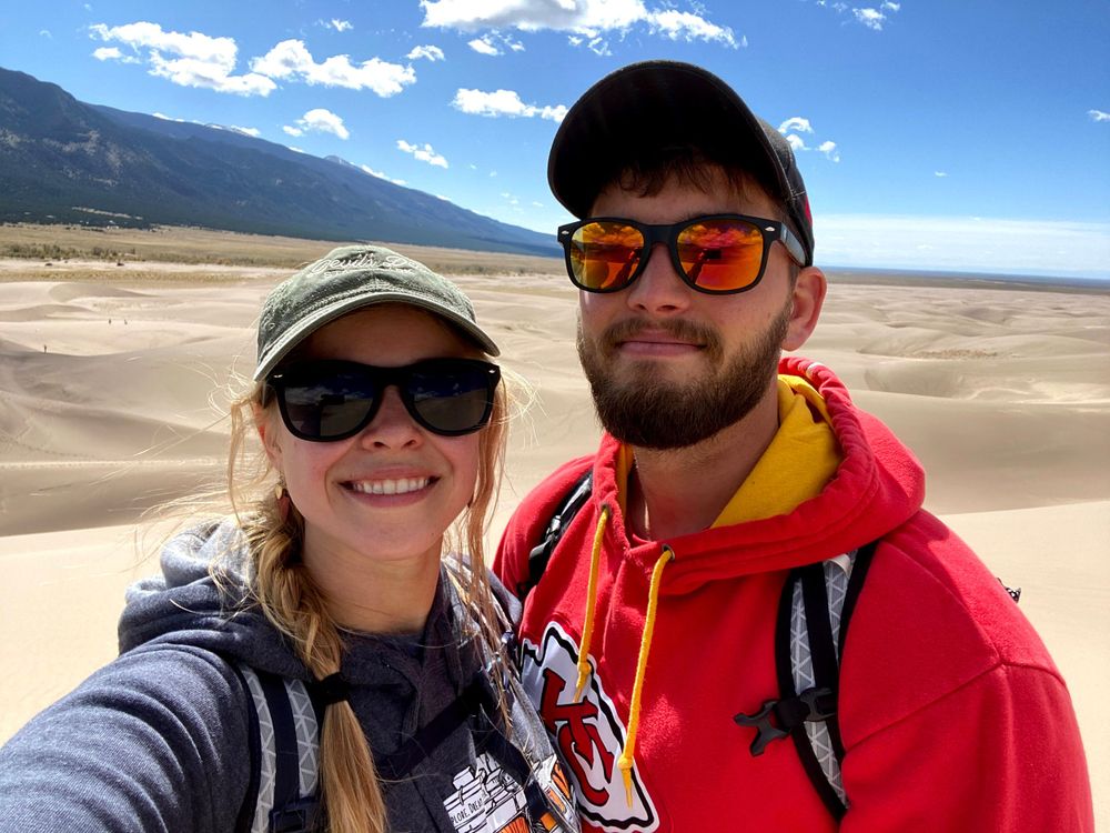 Couple standing on sand dune in Colorado