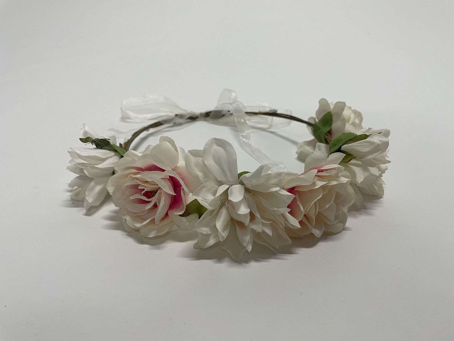Delicate floral crown made with white and pink roses on a light background.