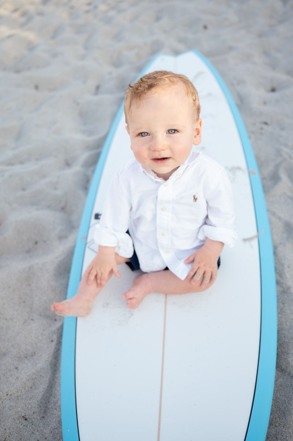 One year old photoshoot session beach surfboard smiling candid cake smash in the sand sunset Melbourne Cocoa Vero Florida Brevard County