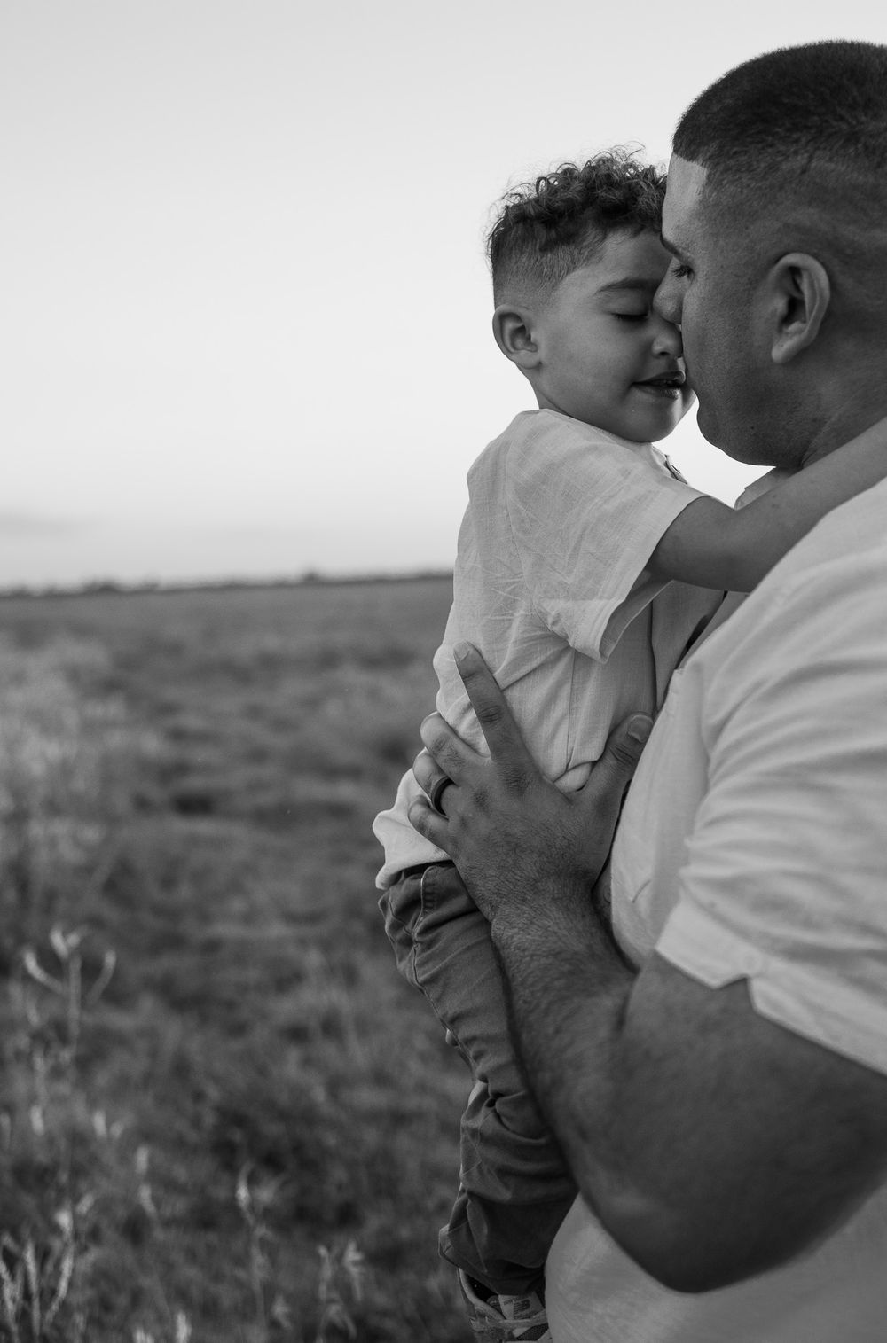 Dad holding son cuddling field emotional daddy and me Photoshoot session Candid Palm Bay Melbourne Cocoa Beach Vero Florida Brevard County