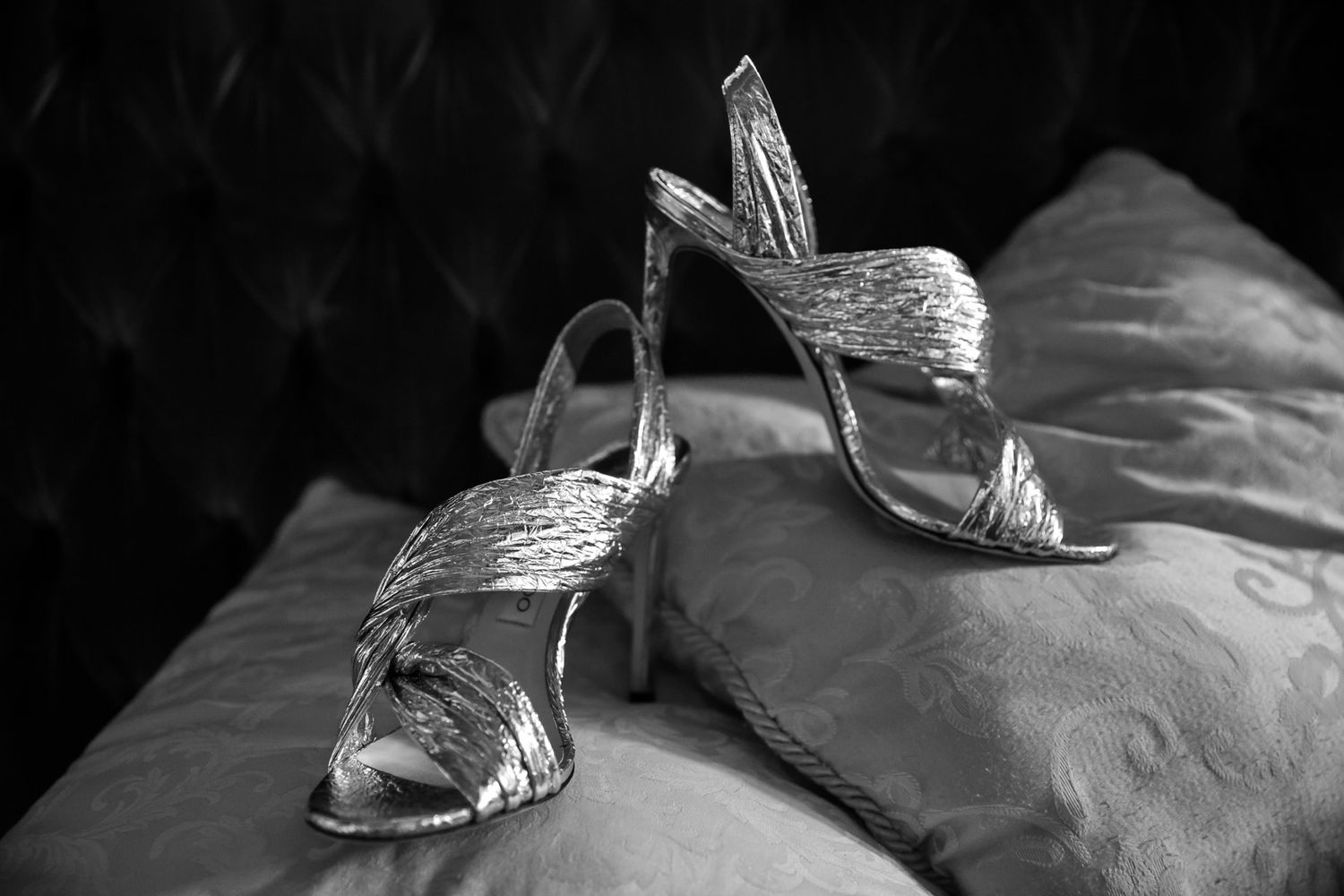 Artistic black and white photos of elegant dress shoes on textured fabric.