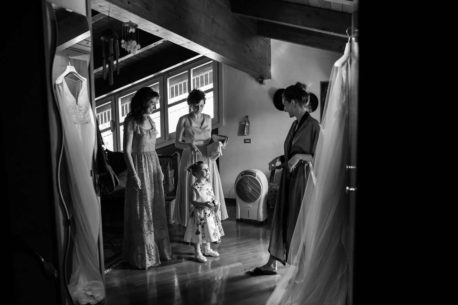 Wedding dresses displayed in a room with dramatic lighting and shadows.