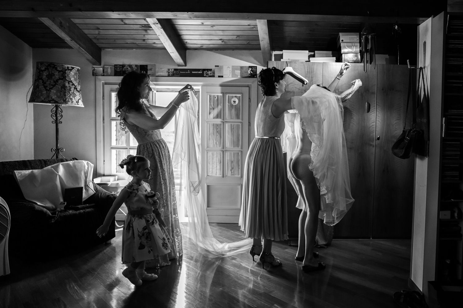 Black and white candid shots of a wedding ceremony in a church corridor.