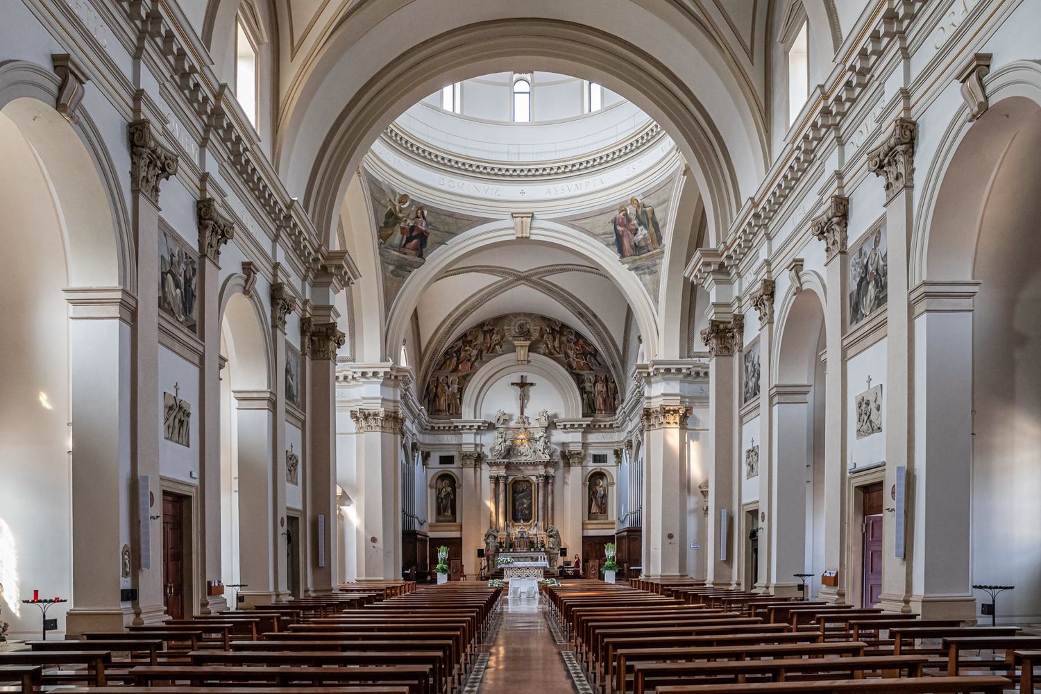 Interior panorama of a classical church with white columns and vaulted ceilings.