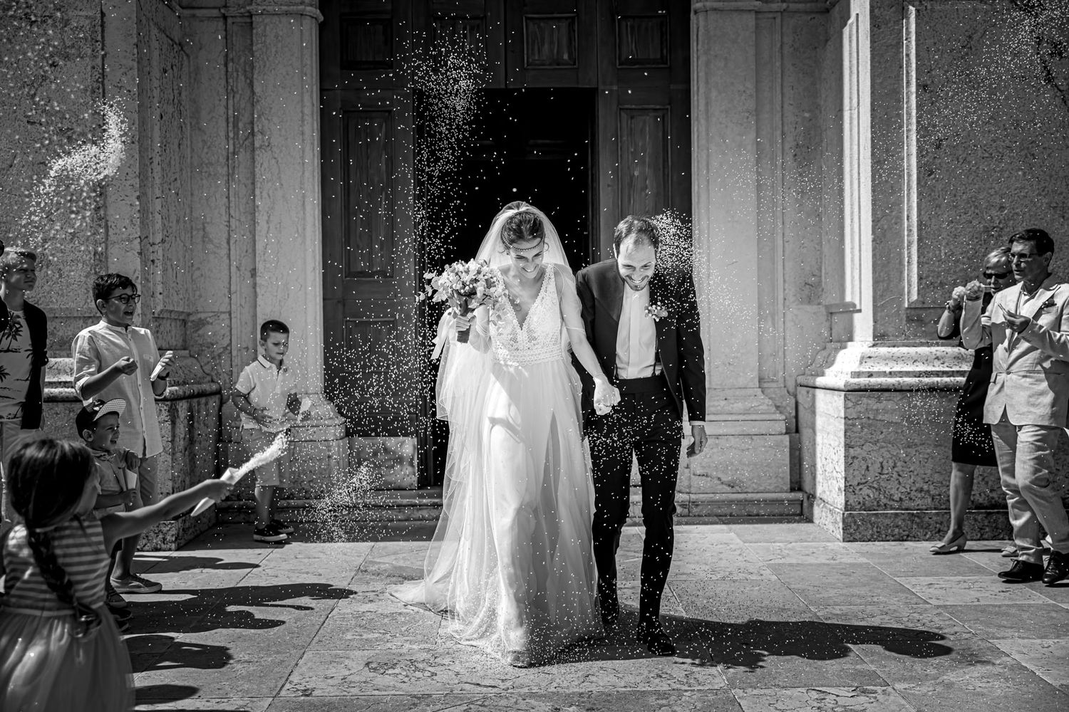 A black and white wedding photo sequence showing a couple walking through a grand architectural space.