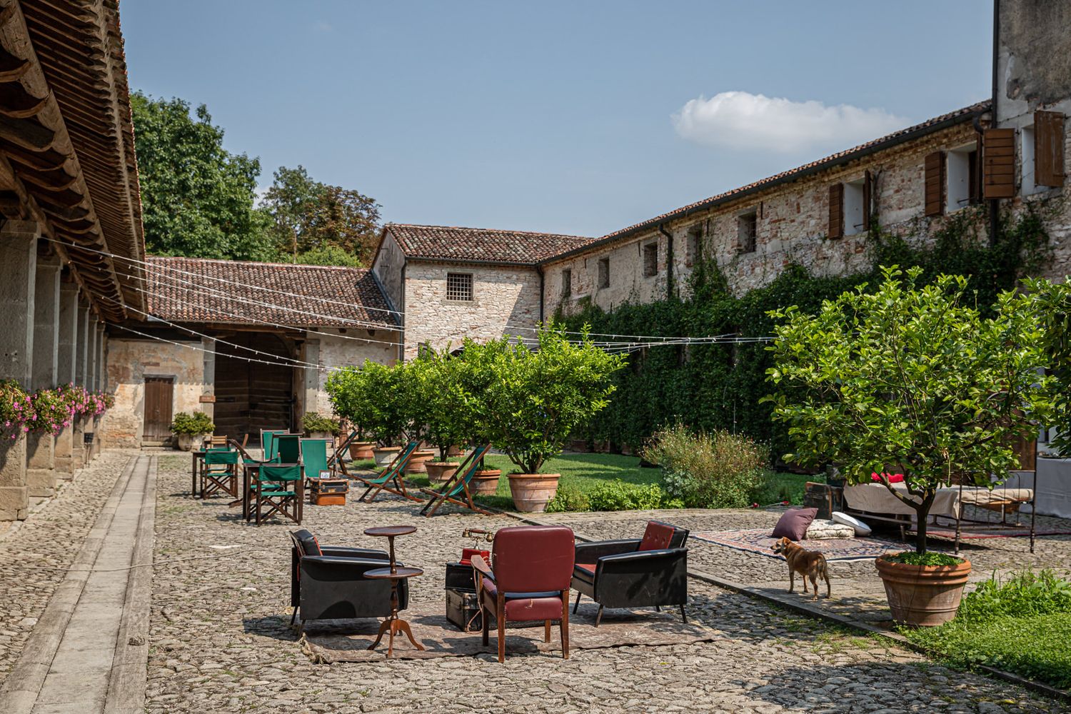 Stone patio with outdoor lounge furniture at a rustic Italian villa venue.