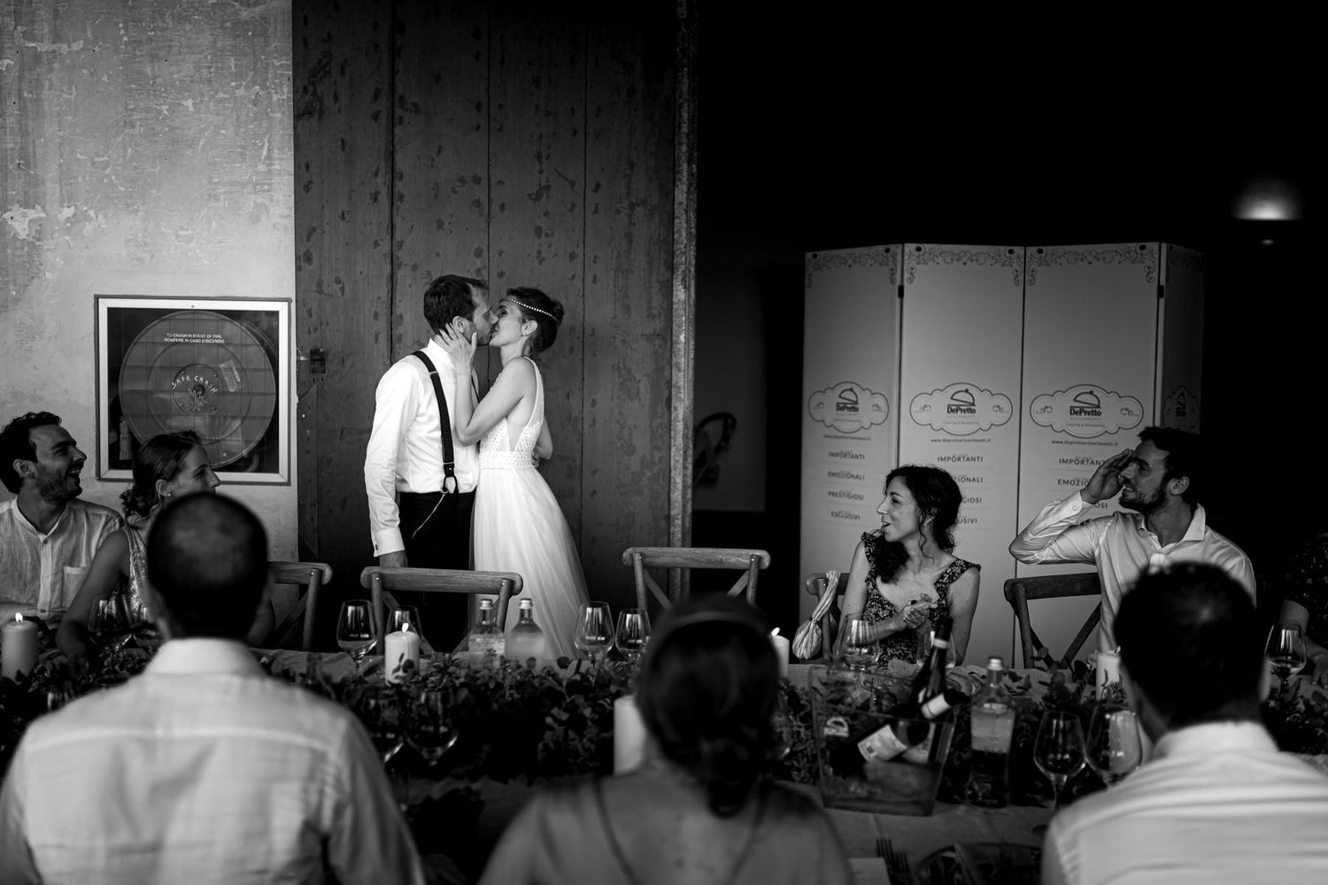 Dramatic black and white photo of wedding reception venue with moody lighting.