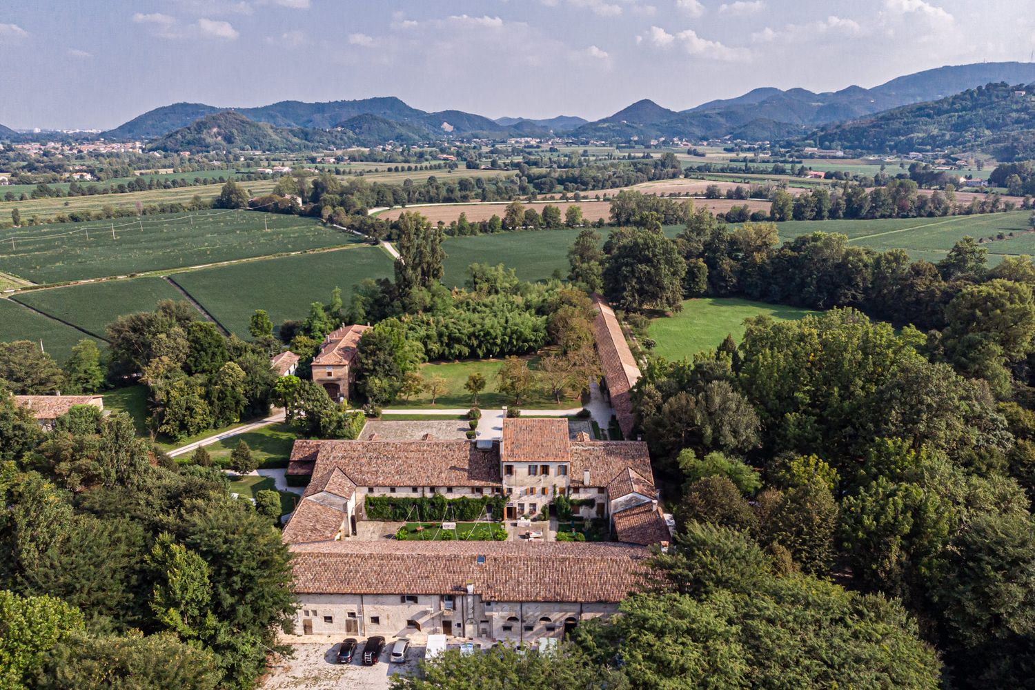 Panoramic aerial view of an Italian villa estate surrounded by rolling hills and countryside.