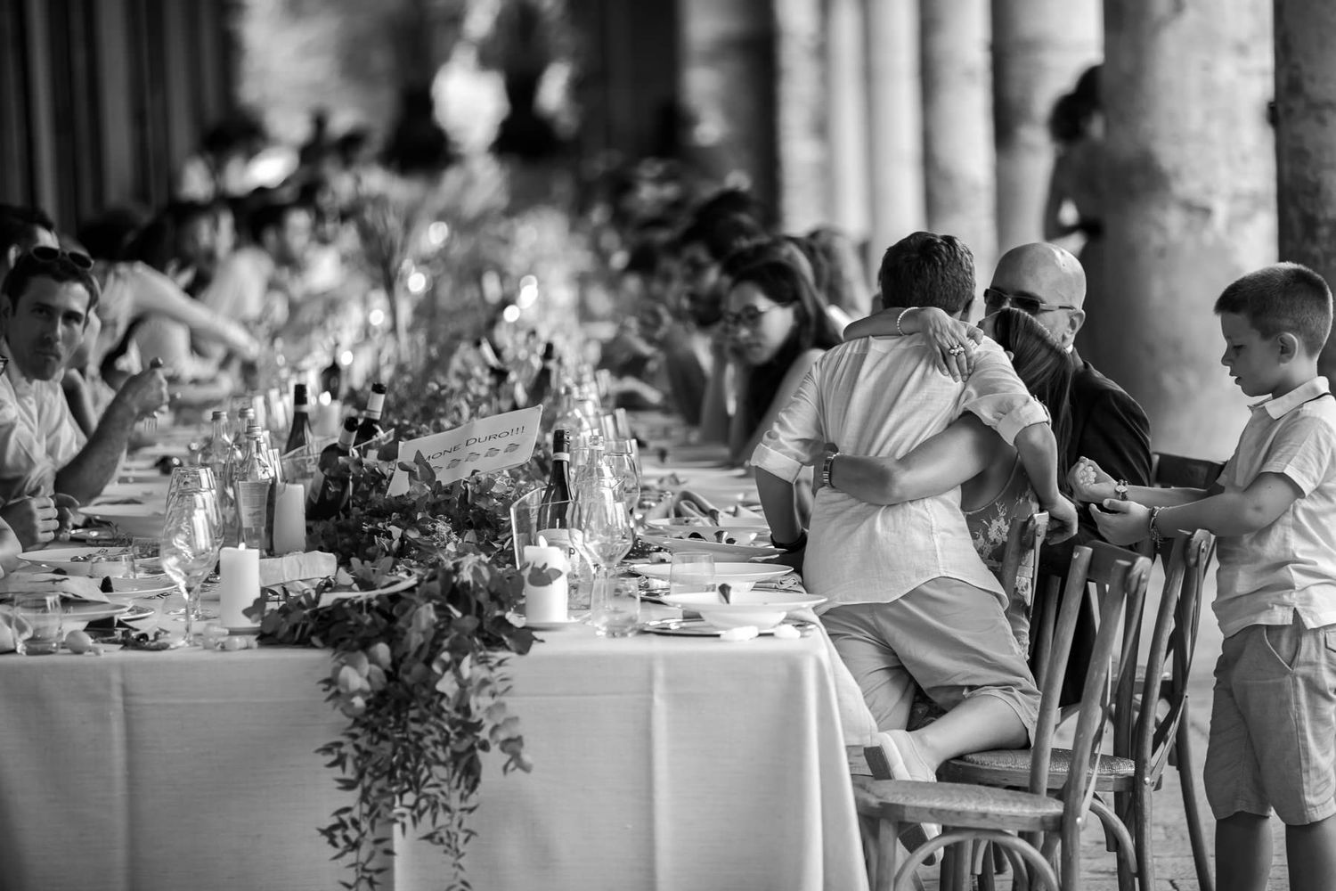 Wedding reception dining area with long tables and columns creating an elegant atmosphere.