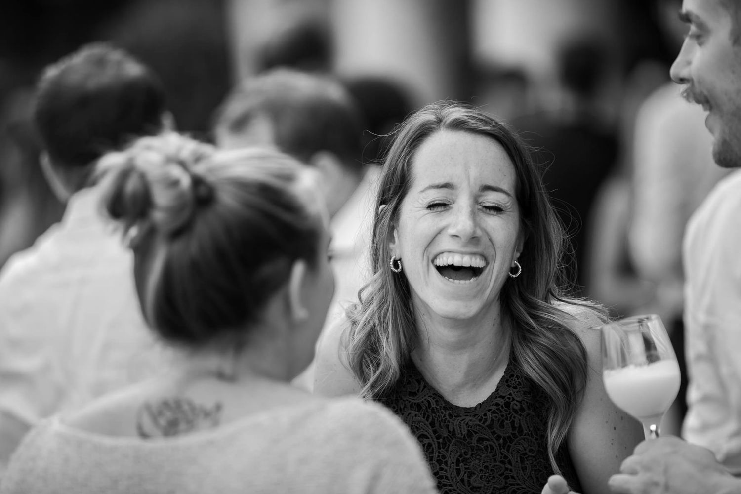 Black and white candid photo capturing joyful moments at a wedding celebration.