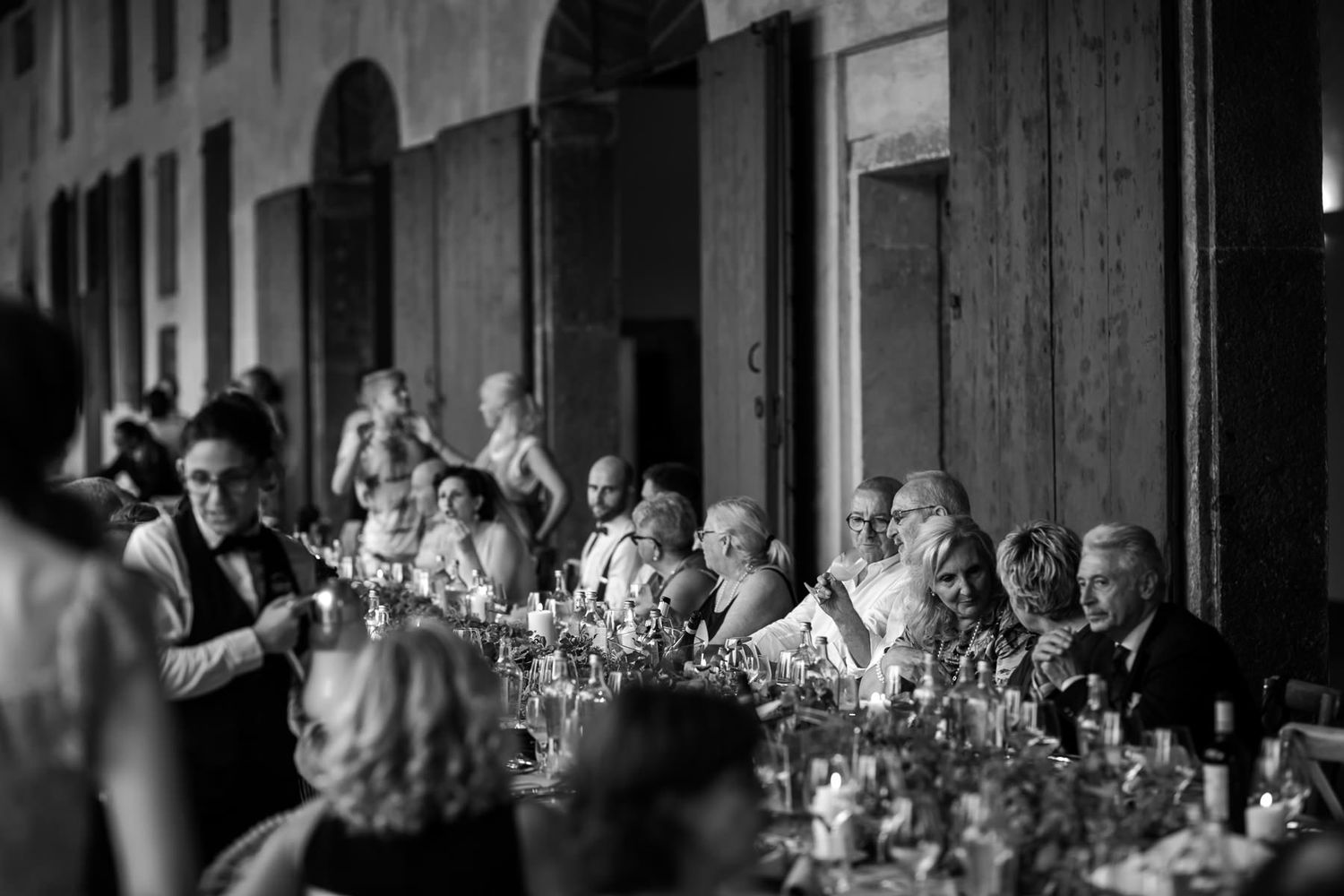 Wedding guests dancing and celebrating at an elegant indoor reception venue.