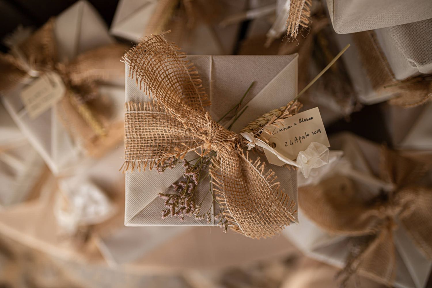 Close-up detail of rustic burlap and lace wedding decorations.