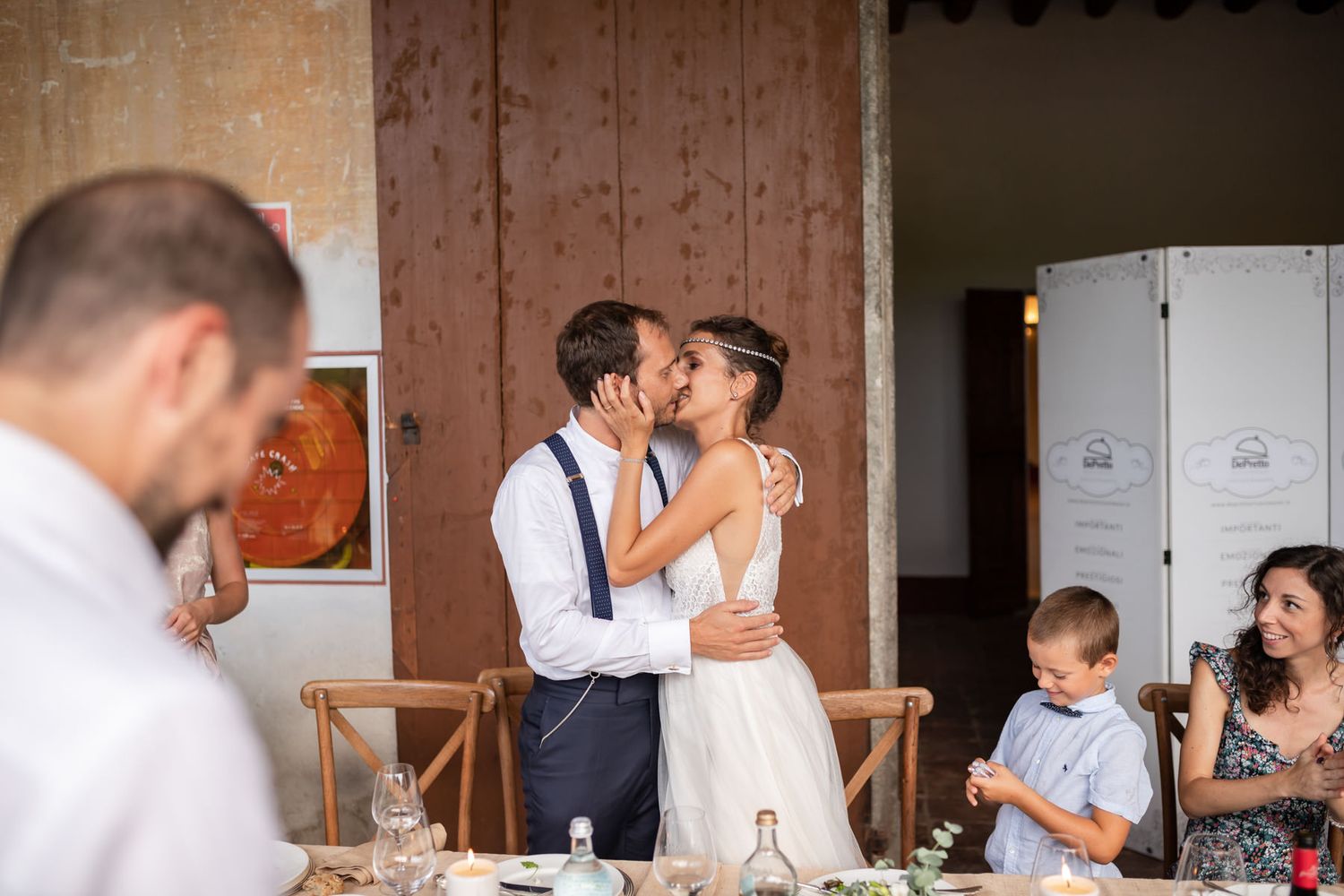 Wedding reception celebration in a rustic barn venue with stone walls.