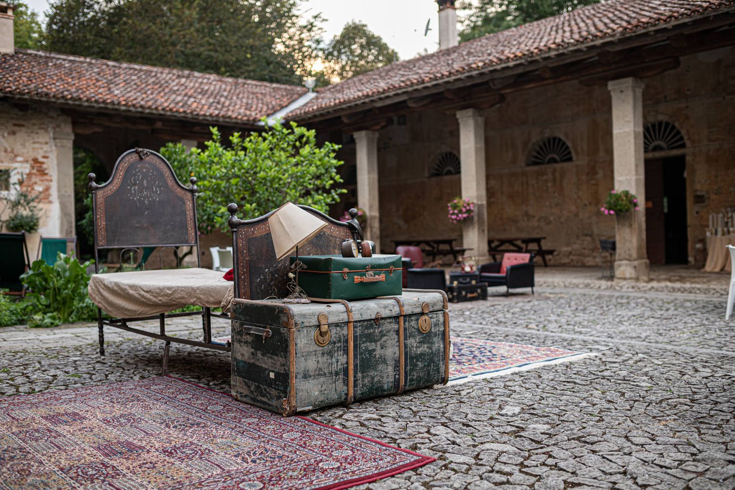 Panoramic view of a rustic stone courtyard wedding venue with tiled roof.