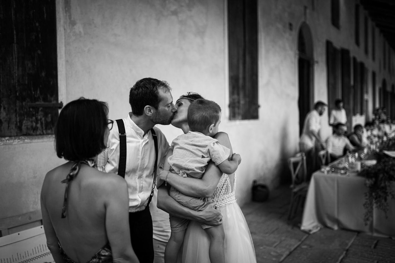 Black and white photos of wedding guests embracing during reception celebrations.