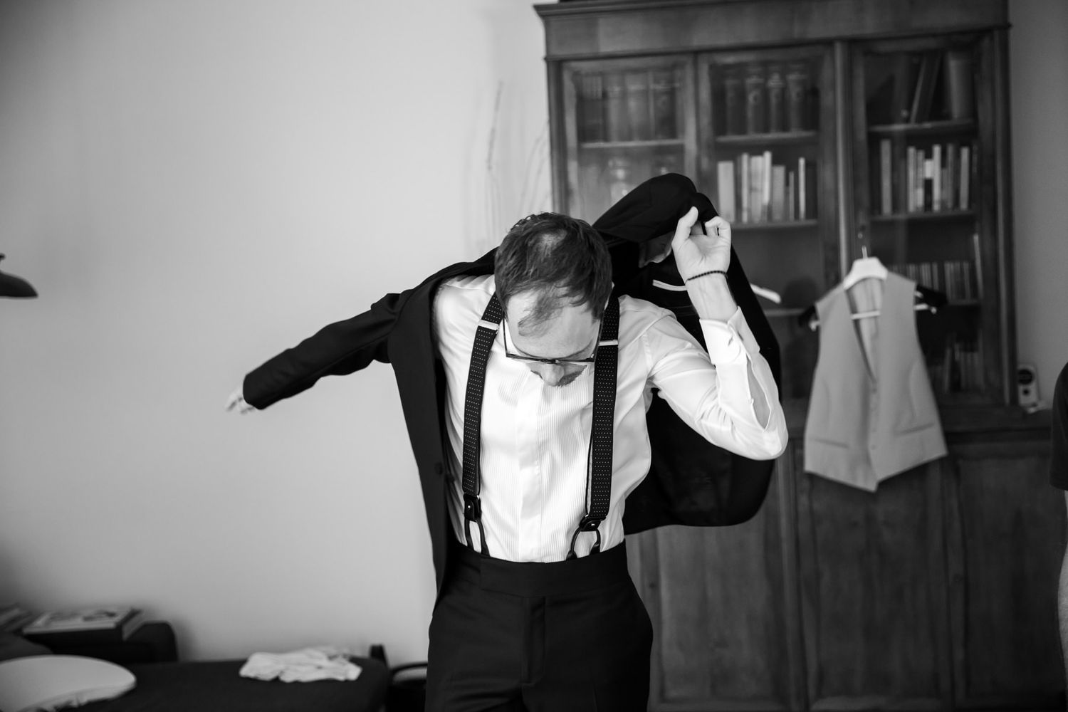 Dramatic black and white photos showing a person getting dressed in formal attire.