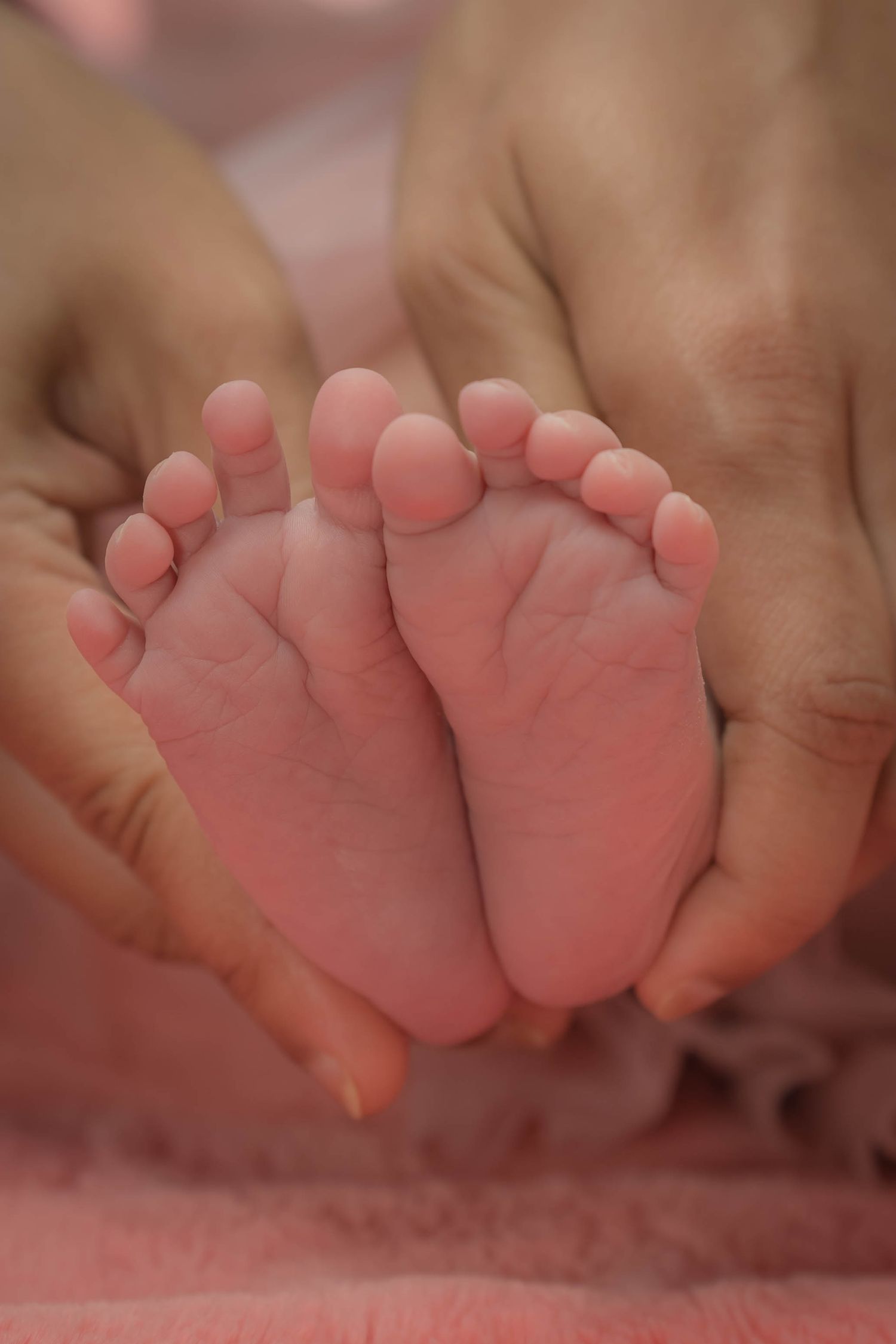 A newborn baby sleeps peacefully, swaddled in blankets and surrounded by soft lighting