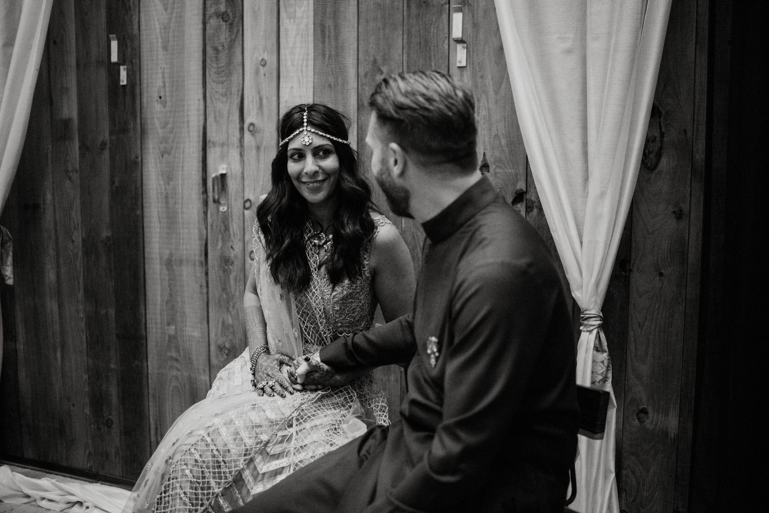 Black and white sequence of couple sharing intimate moments by wooden barn doors.