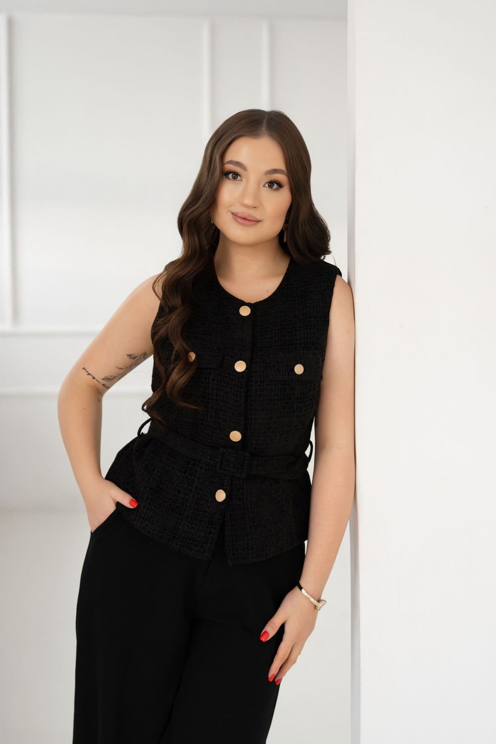 Model wearing a sleeveless black button-up dress with pockets shown from multiple angles against a white background.