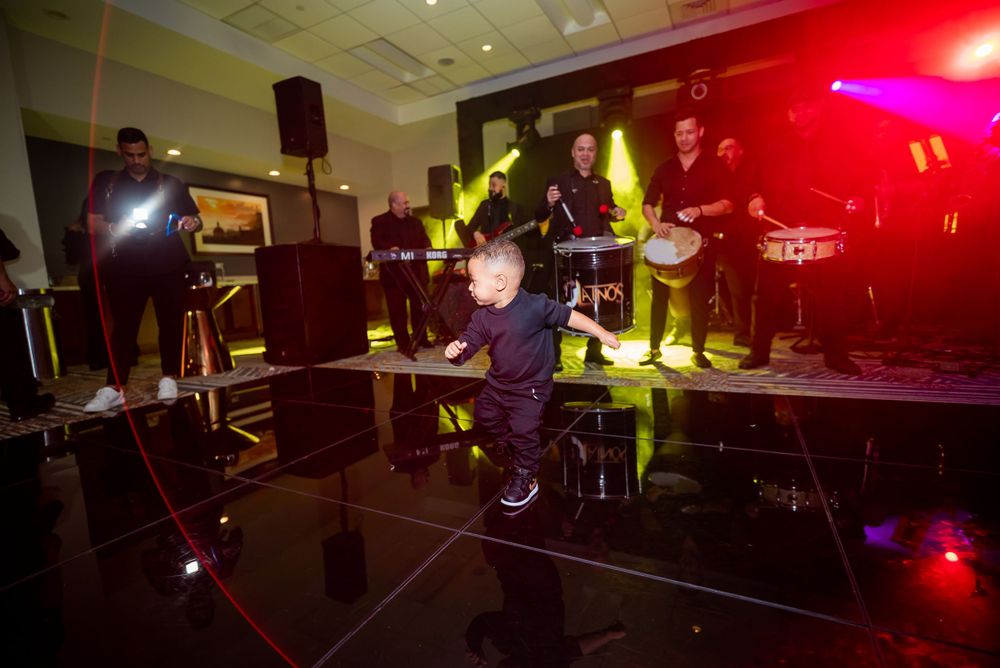 DJ performs at a lively party with colorful lighting and dance floor.