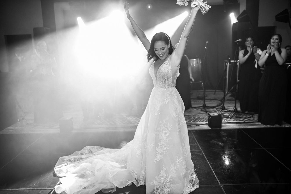 Dramatic backlit scene of celebration in an ornate wedding dress during reception.